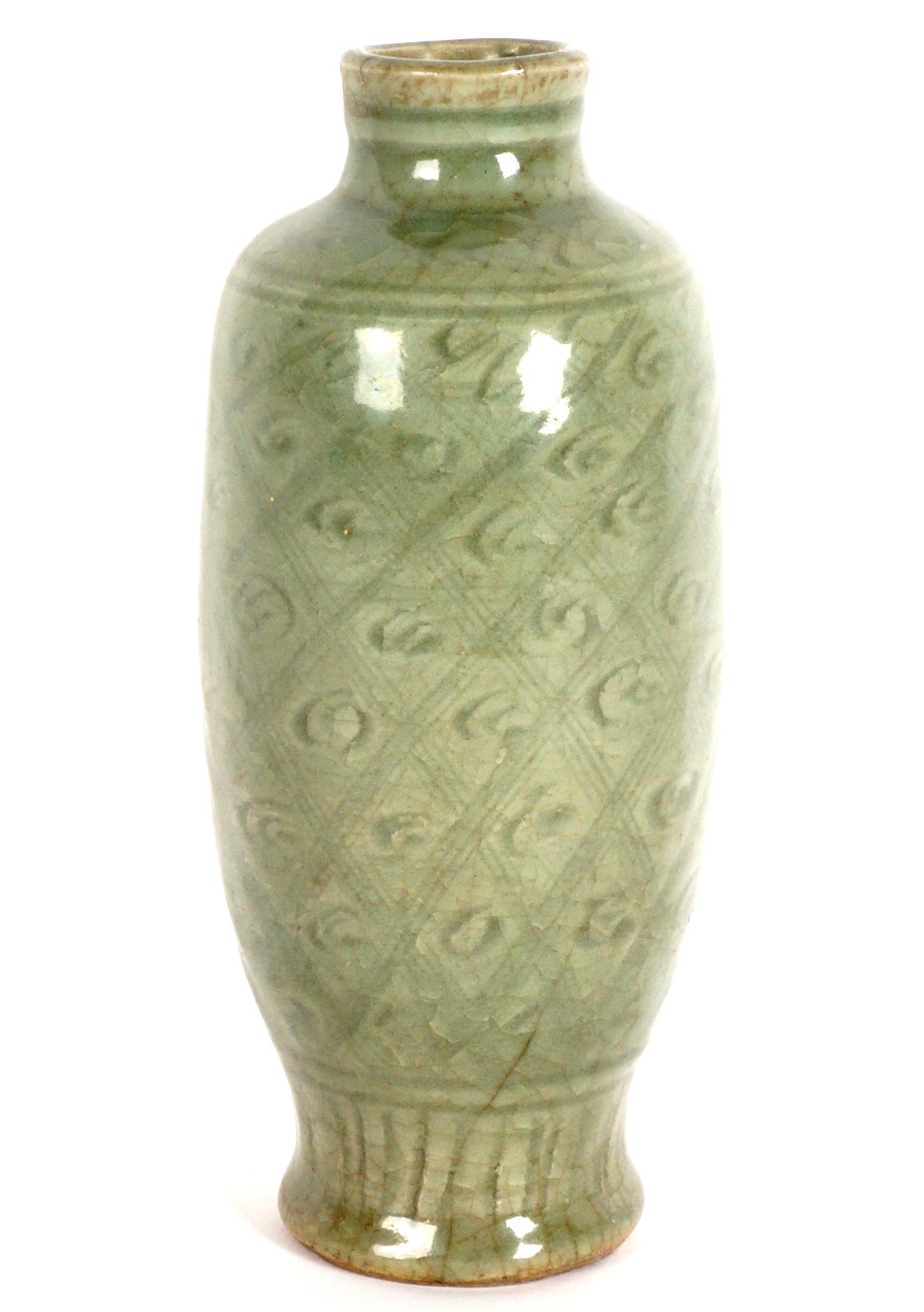 Chinese Lonquan Celadon Vase: Celadon crackle glaze, incised diamond pattern body with clouds, foliate medallions on shoulder, fluted low neck, bears a Jade Dragon label on base, overall 8.25" h. x 3.5". While we believe this piec