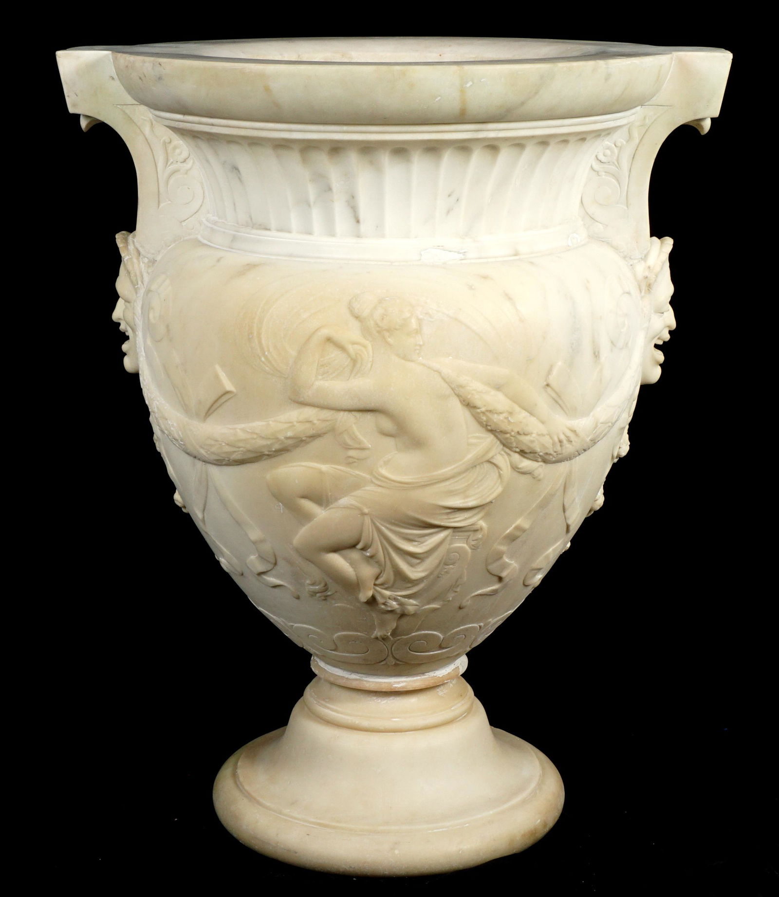 Large Neoclassical Carved Marble Garden Urn: Large carved marble garden urn, fluted neck, body with semi nude maidens and garland swag, masquerons under each handle. Overall 32.75" h .x 26.5" x 22.25". Condition: Repair to foot, small edge chips