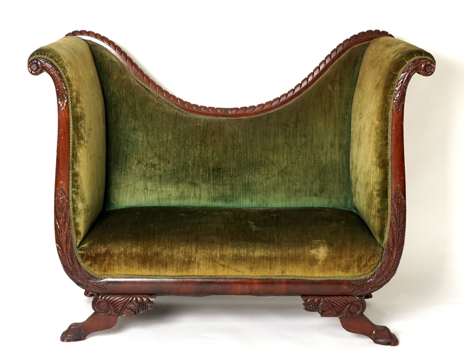 High Back Empire Revival Sofa: Circa 1900, high back carved and shaped top rail, tall scroll arms, carved foliate motif fronts, all on 4 carved paw feet. Green upholstery, overall 48.25" h. x 61.25" x 23.5". Condition: Wear consist
