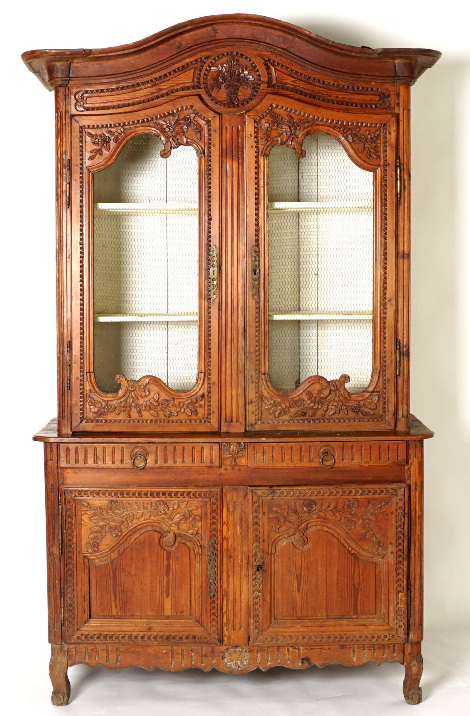 18th / 19th C Buffet Deux Corps: Carved crest, center medallion with flower basket, two carved doors with screen wire, painted interior with two shelves. Base with two drawers over two doors, on four feet, overall approx. 96" h. x 57