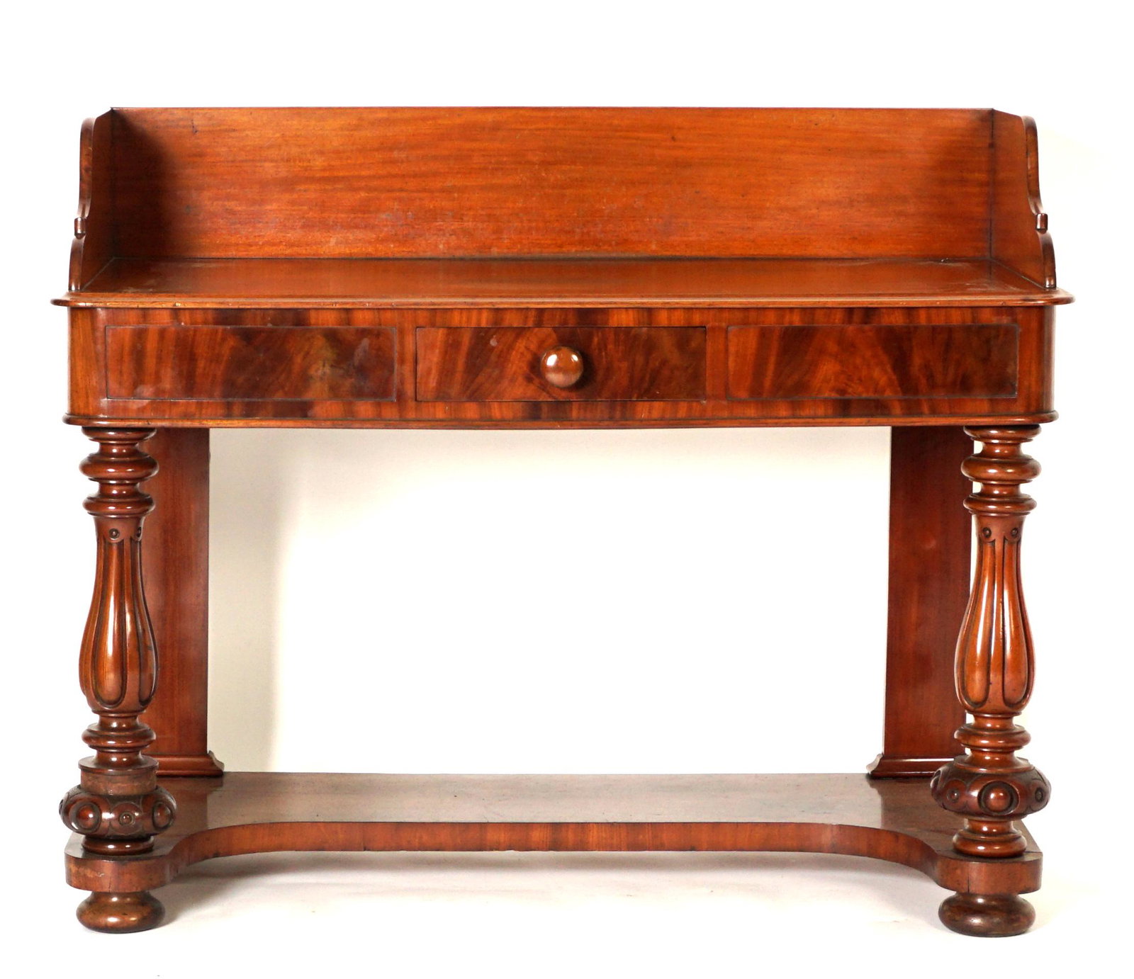 English Mahogany Server: Mahogany backsplash with shaped sides, single drawer front, carved, fluted, and shaped front supports. Open lower shelf, on bun feet. Overall 38" h. x 47.5" x 23". Condition: Veneer bubble at drawer,
