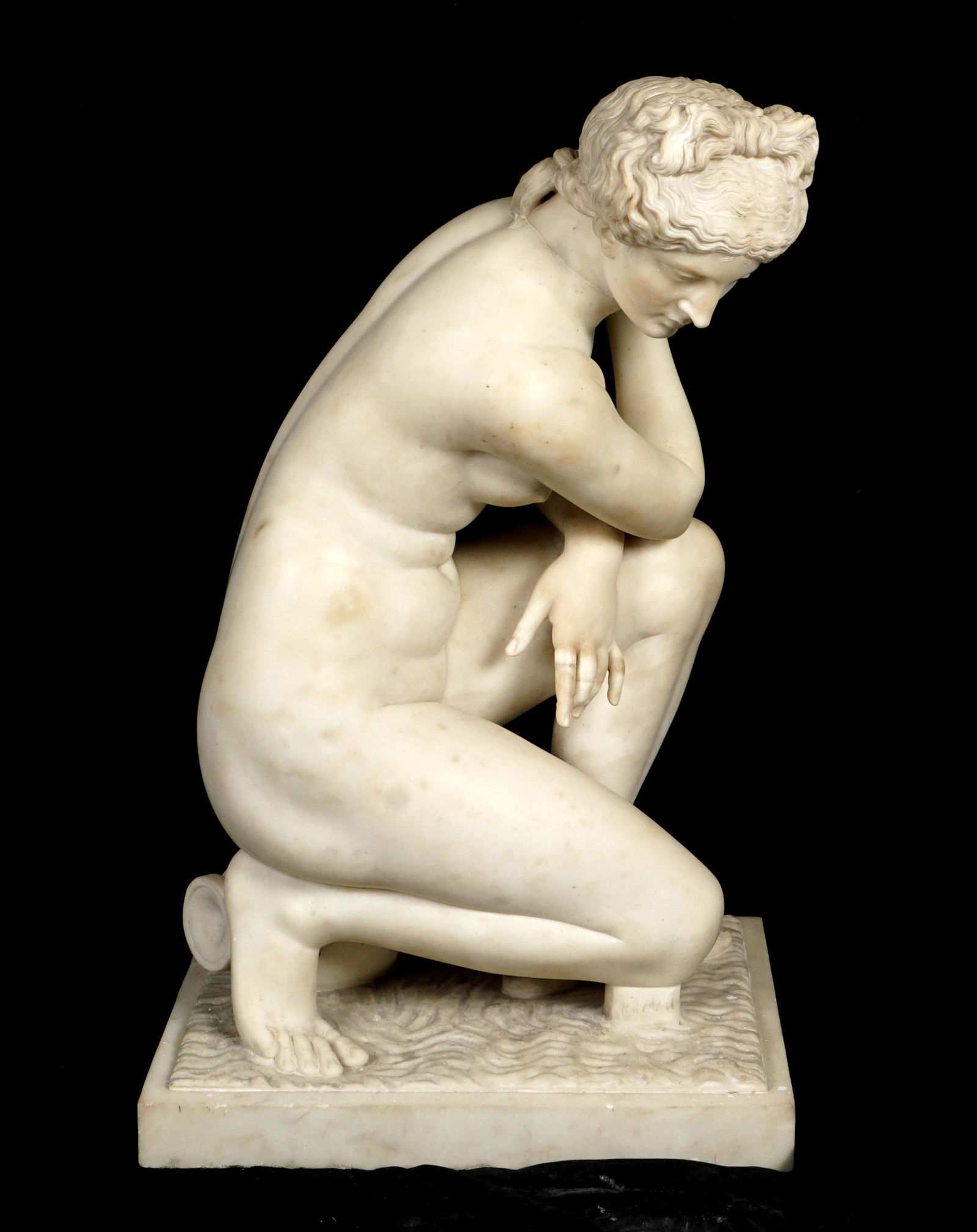 Carved Marble Statue of Crouching Venus: Figure of kneeling Venus with urn under backside, no visible signature. Overall 33.75" x 18" x 20.75". Condition: Repairs and missing finger. Older professional repair to neck.