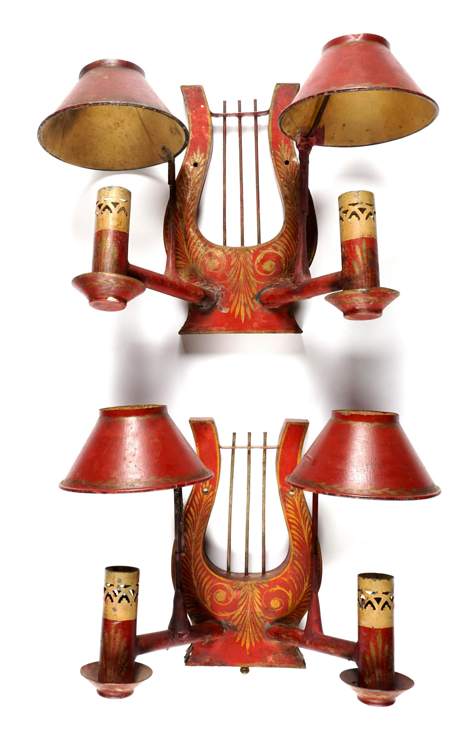 Pair Lyre Form Toleware Sconces: Red ground, stenciled designs, lyre form body, 2 candle holders with shades, unmarked. Overall 8.75" h. x 12.5" x 5.75". Condition: Wear, one arm in need of repair, one missing switch.