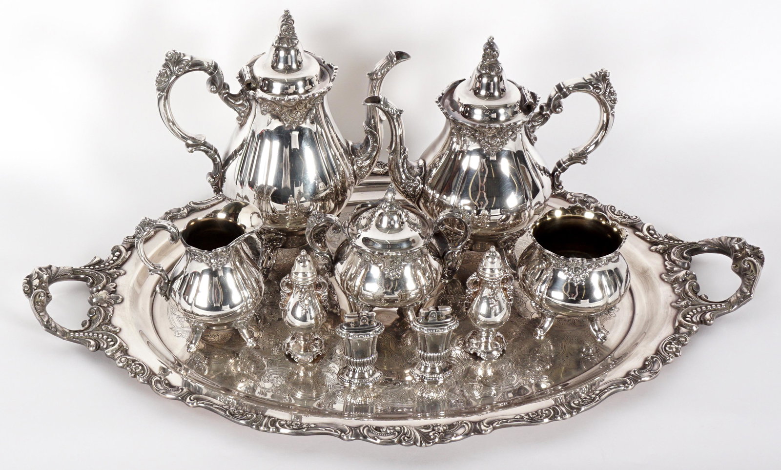 Wallace Baroque Silverplate Tea & Coffee Service: Eight piece service set in the Baroque pattern by Wallace to include coffee pot (11" h.), teapot (10"), open creamer (5.5"), covered sugar, open waste bowl, salt & pepper shakers, double handled tray