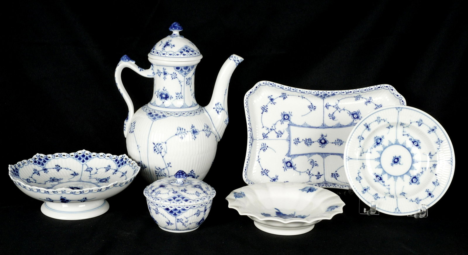Six Piece Royal Copenhagen Blue & White Porcelain: Six pieces total, five in the Blue Fluted pattern, half lace to include coffee pot and lid (9.75" h.), covered sugar (3" h.), rectangular tray (9.5" x 6.75"). Full fluted low footed cake plate (6.75"