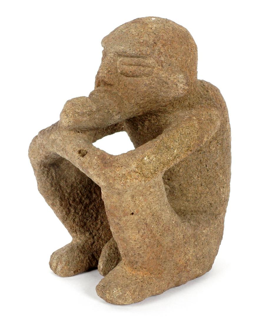 Pre-Columbian Carved Volcanic Rock Figure: Figure of a seated man eating a banana, arms resting on knees, overall 7" h. x 4.25" x 6".