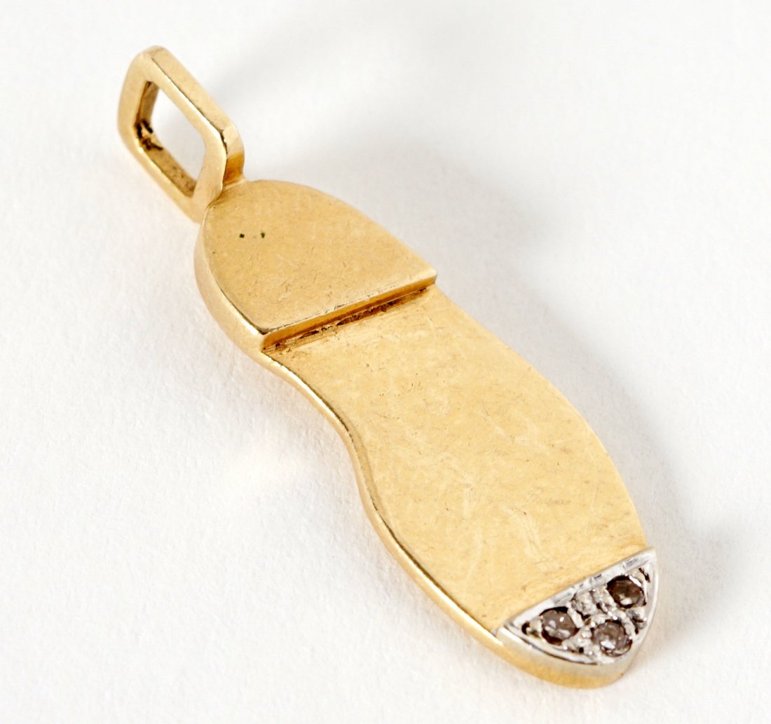 Sylvia Miles 14K Gold & Diamonds Shoe Pendant: Small 14k yellow gold pendant in the form of the sole of a shoe, three prong set diamonds at tip. Marked GN, 14k, 1.25" long, approx. 2 grams inclusive. From the Sylvia Miles estate.