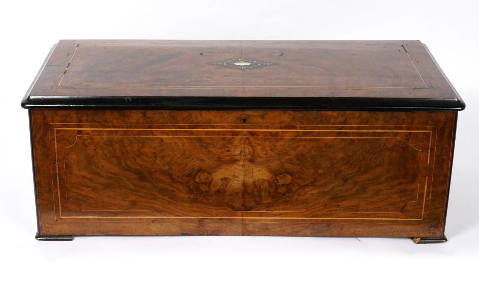 Inlaid Swiss Cylinder Roll and Bells Music Box: Late 19th Century. Hinged lid with inlaid mother of pearl and ebony inlaid medallion, string inlay to lid and sides, on four feet. 15.25" cylinder roll movement with six bells, all teeth intact. Curre