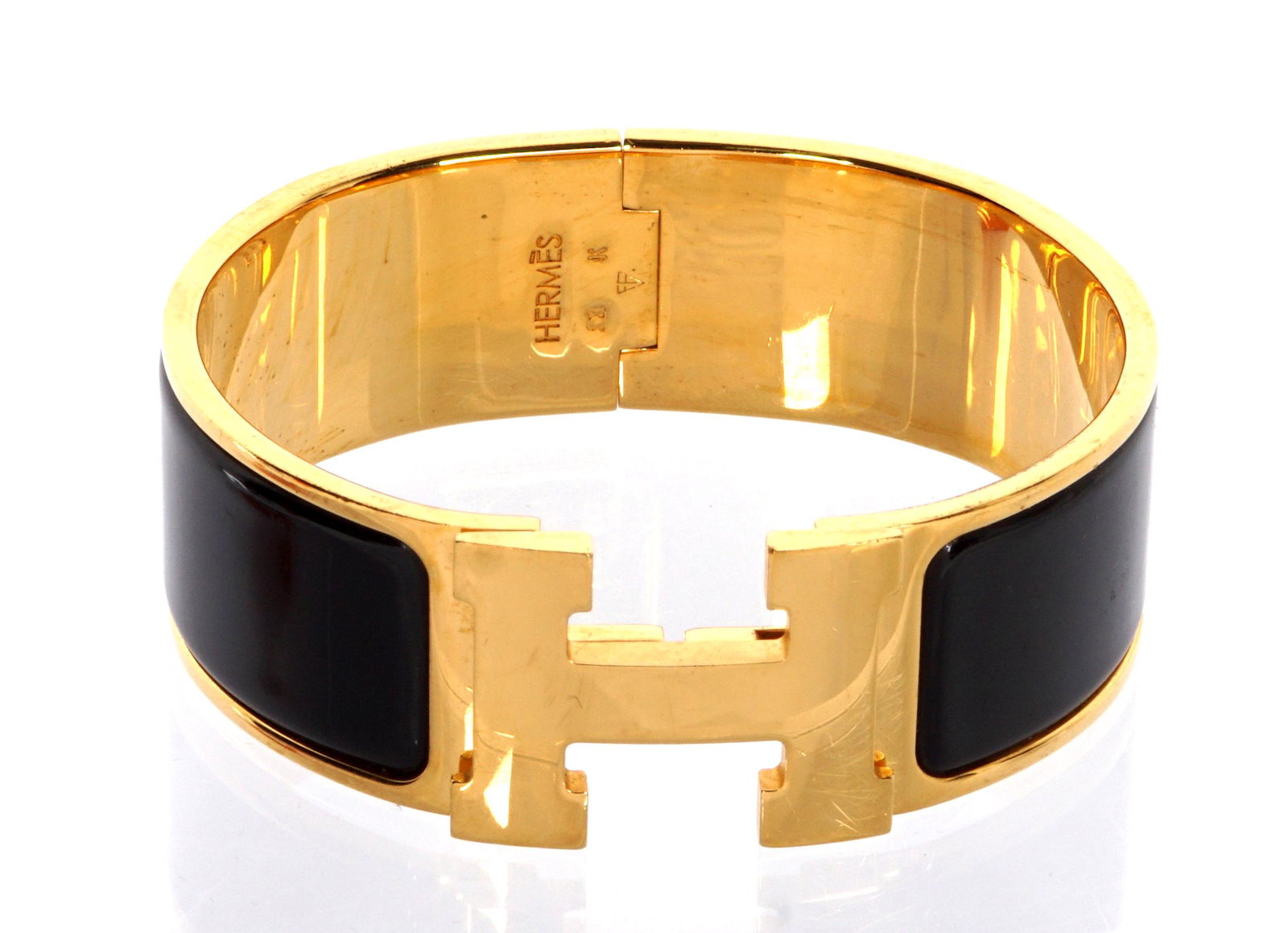 Hermes Gold Plated H Clic Bracelet: Gold plated, black enamel panels, well marked, 2.25" dia., sold with a Hermes box.