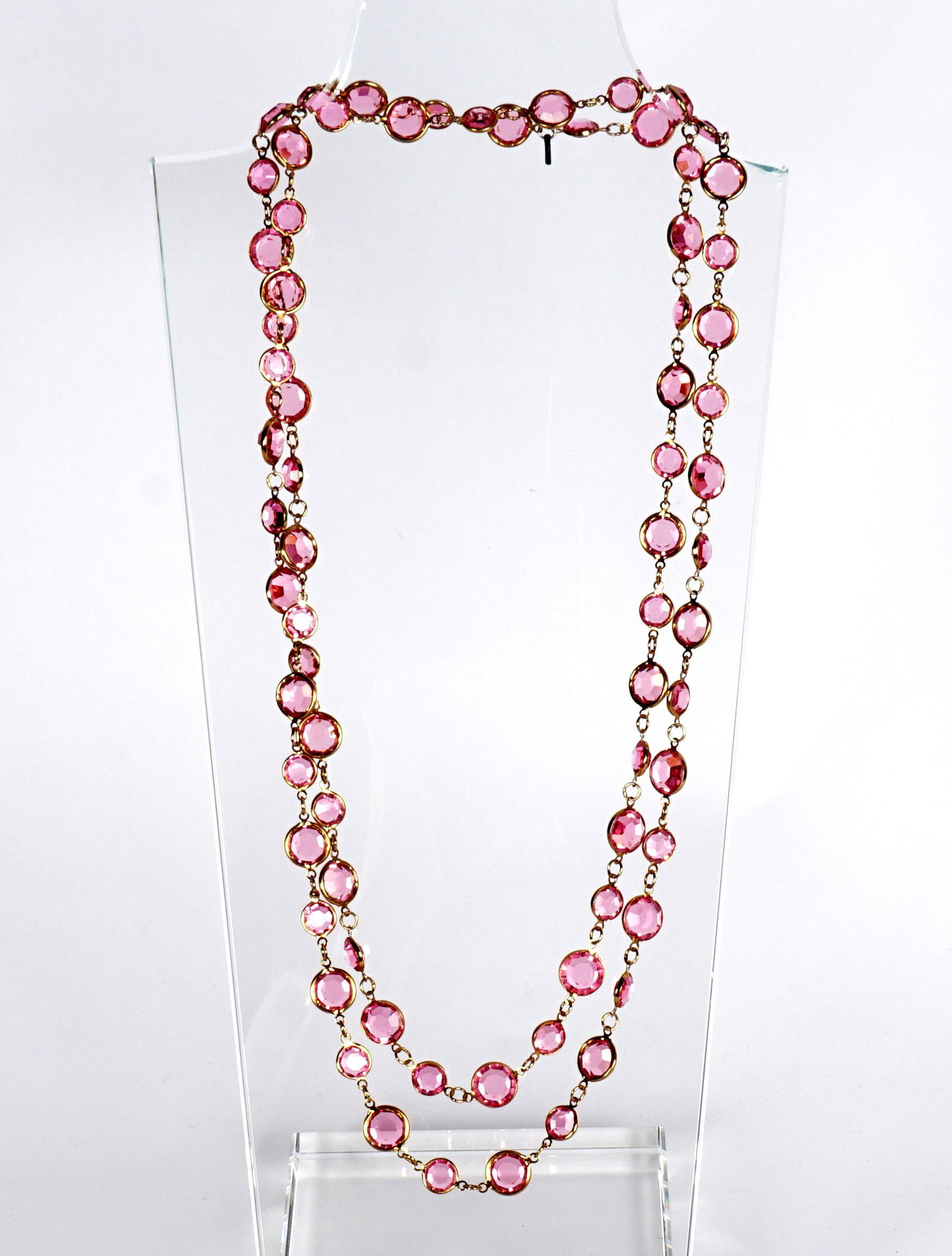 Pink Glass Opera Length Gold Toned Necklace: Faceted pink glass, bears a small Chanel tag however we cannot guarantee it to be Chanel, overall 50" long. Sold with a Chanel box.