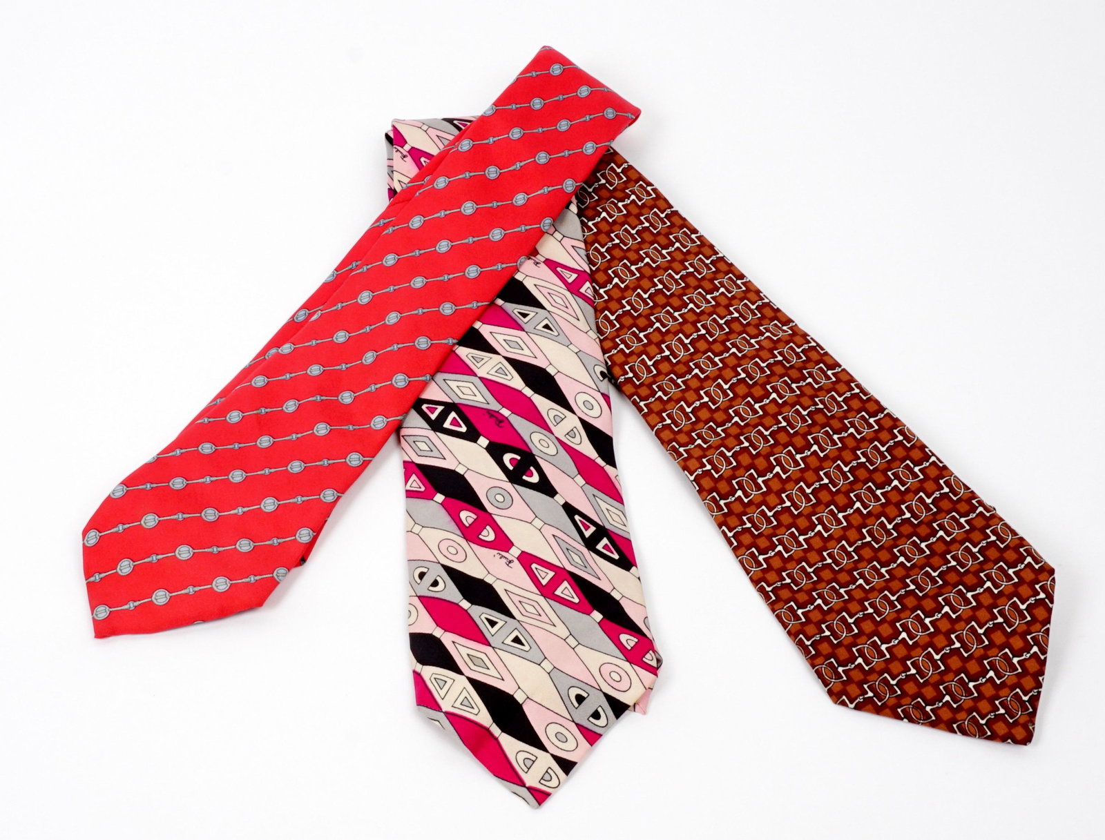 Two Hermes and a Pucci Silk Tie: Three pieces total to include two Hermes, on with red primary color, the other brown. The Pucci tie with pinks, purple, and black.