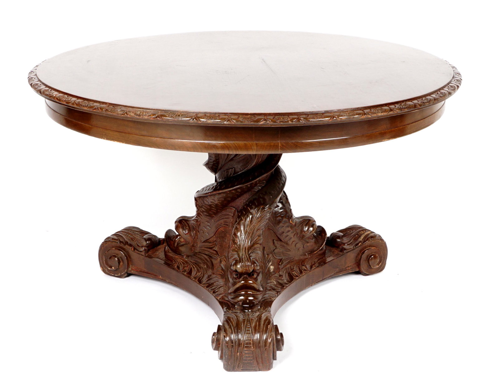 French Carved Figural Dolphin Low Table: Round top low table, carved edge, pedestal base with three stylized figural dolphins, three carved splayed legs ending in foliate scrolls. Overall 24.75" h. x 41.25". Condition: Minor wear to top, scr