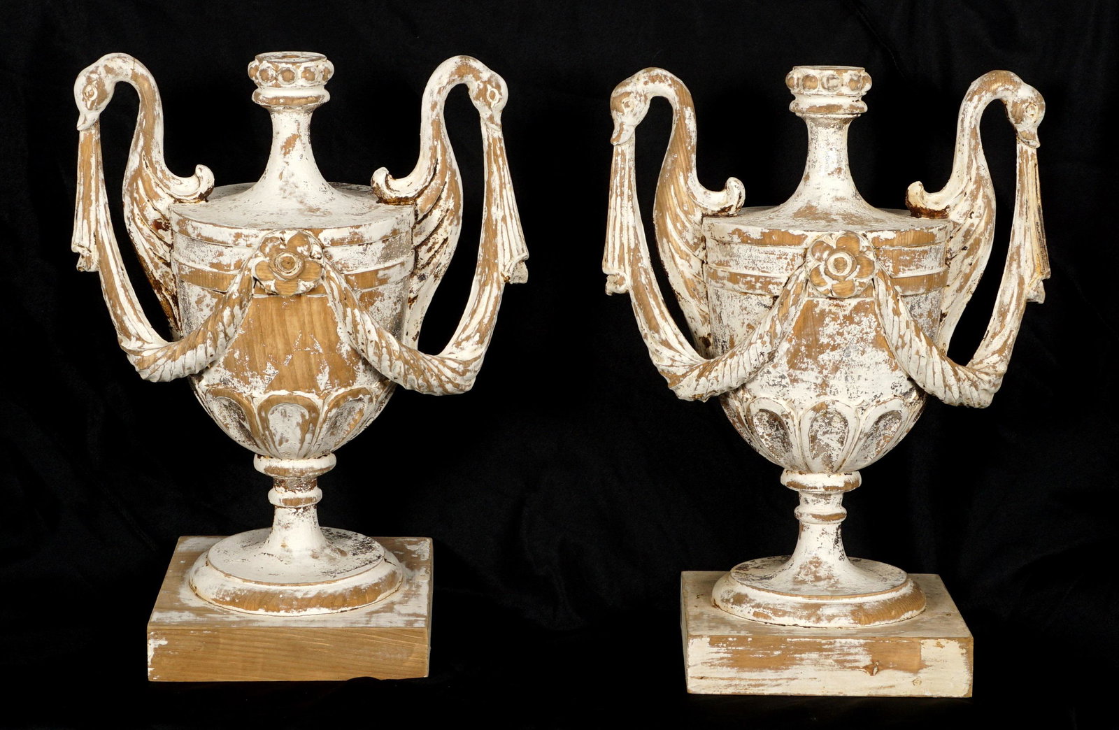 Pair 1950's Italian Carved Wood Urns: Antiqued white painted finish, double figural swan handles, garland, and floral medallions. Overall 19" h. x 15" x 8.75".
