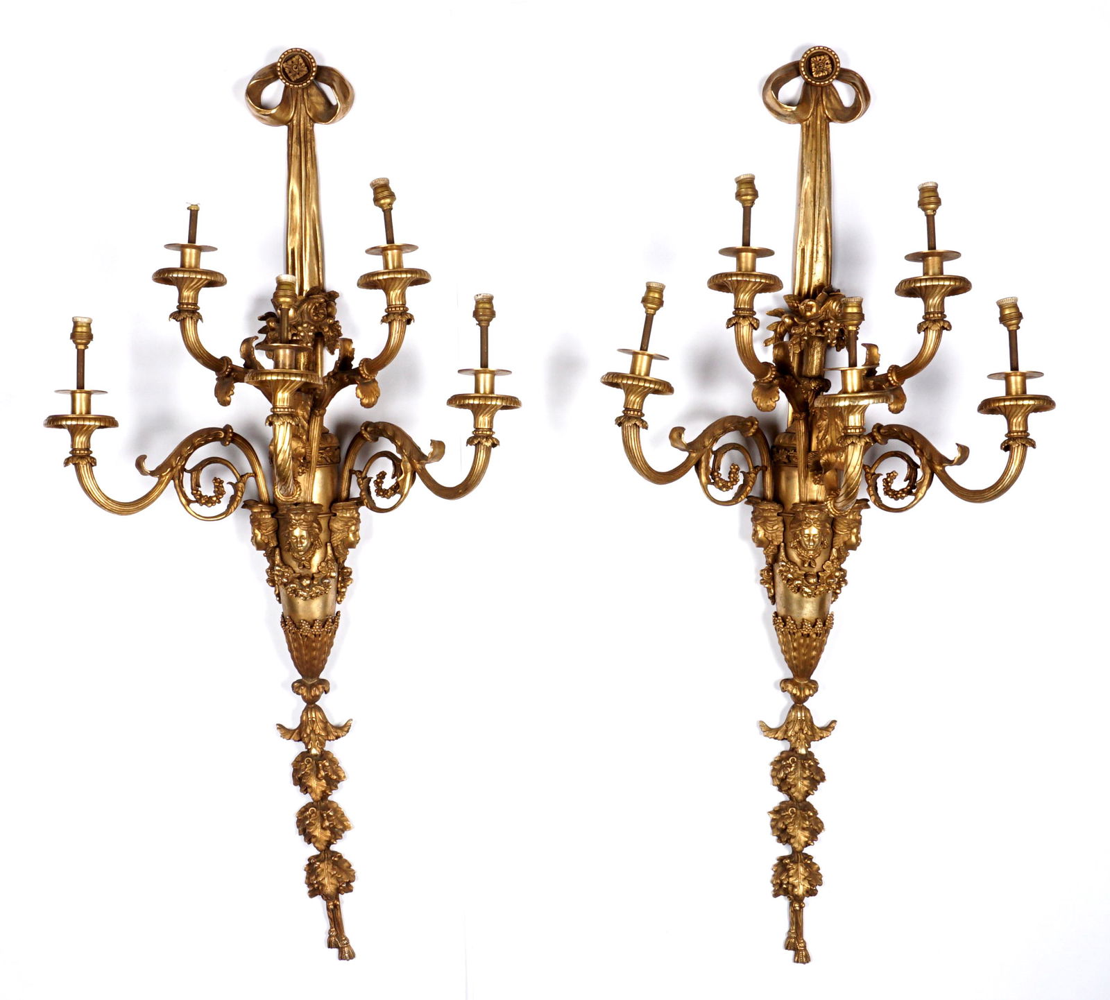 Pair of Palatial French Bronze Five Light Sconces: Early 20th Century, electrified ribbon finial over five scroll arms, foliate and masqueron motifs, foliate swags, lower oak leaf clusters, hanging tassels. Overall 45.25" x 20.25" x 12.25".