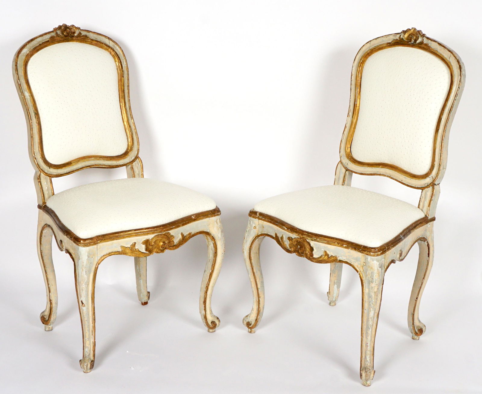 Pair 18th Century Italian Side Chairs: Medallion back, carved foliate scroll top tail, frame with paint and gilt decoration, carved and shaped serpentine skirt, shaped legs ending in scroll feet. Faux ostrich upholstery, overall measures 3