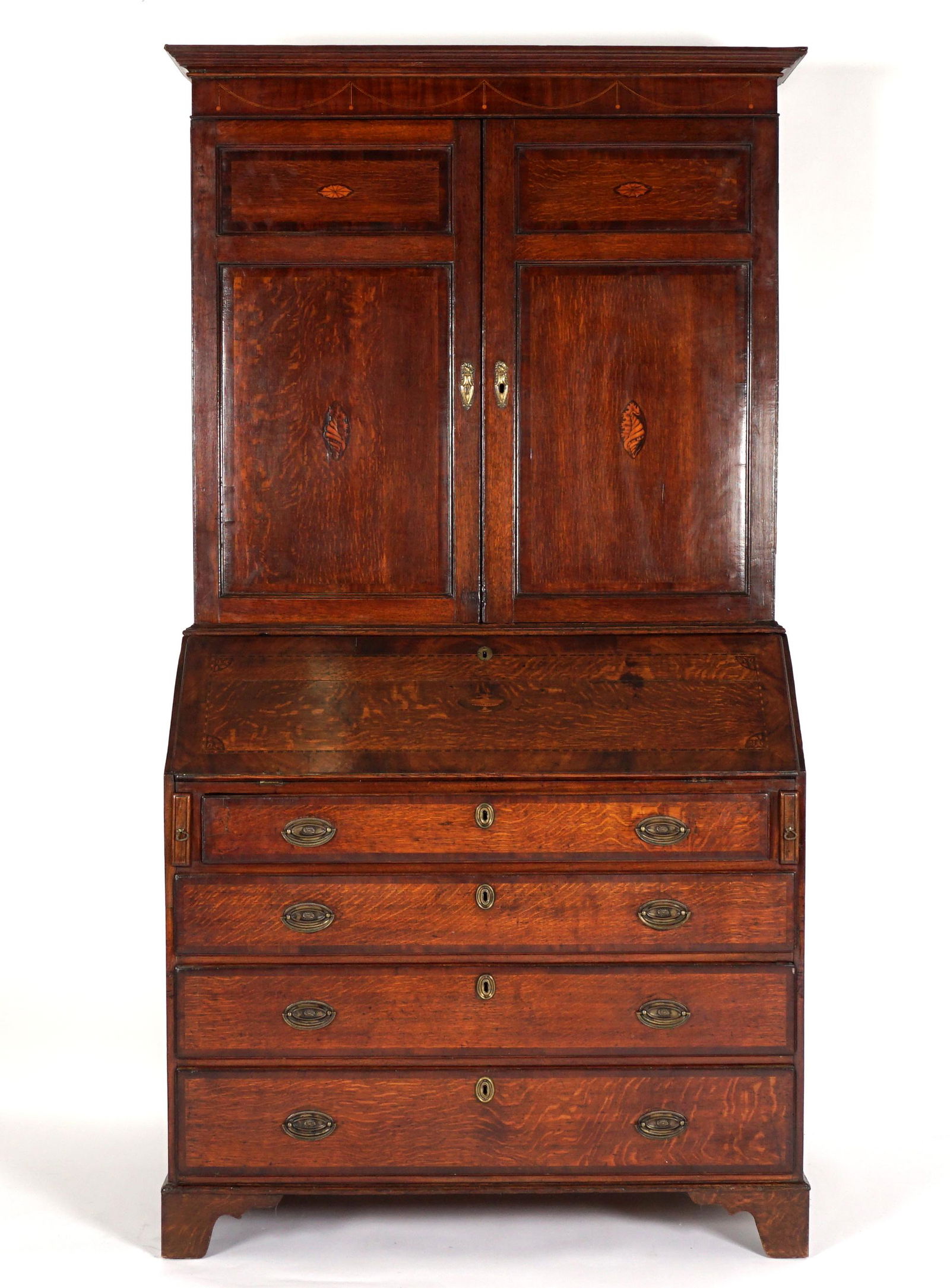 Georgian English Oak Inlaid Secretary Bookcase: Circa 1780, molded cornice over parquetry inlaid pediment, double blind doors with shell and paterae medallions. Marquetry urn inlaid slant front secretary base, fitted interior with shaped valences,