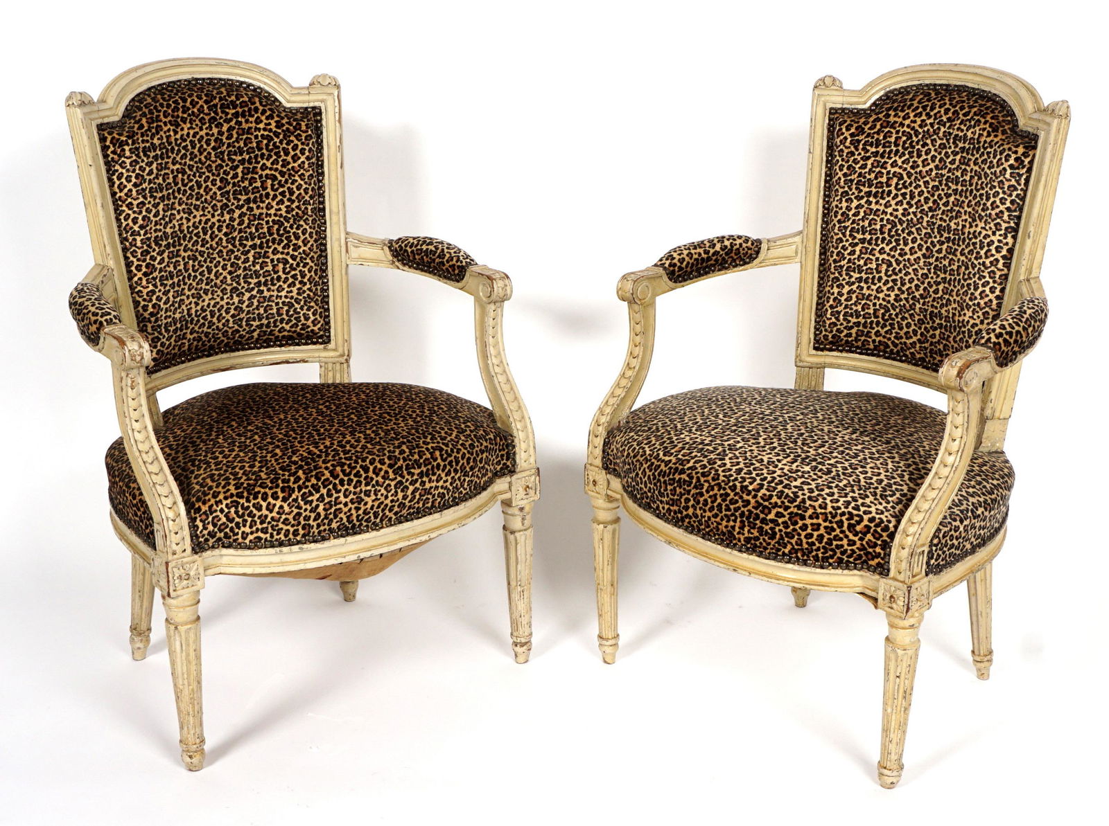 Pair 19th C. Louis XVI Fauteuil Chairs: Carved and shaped painted frames, faux leopard spot upholstery, tapered fluted legs, overall 35.5" h. x 23.5" x 21". Condition: Wear to paint.