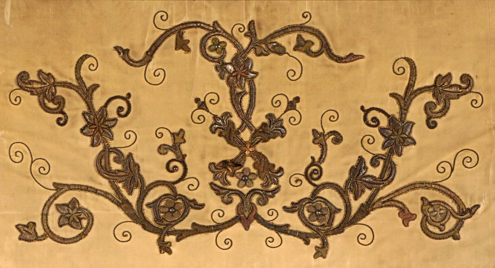 18th C Continental Framed Silk Embroidery: 18th Century Presumably a show pillow cover. Trapunto metallic thread couch-stitched on silk in arabesque pattern. Sight size 11.5" x 21.75", framed 28" x 38". Condition : good, acceptable with age