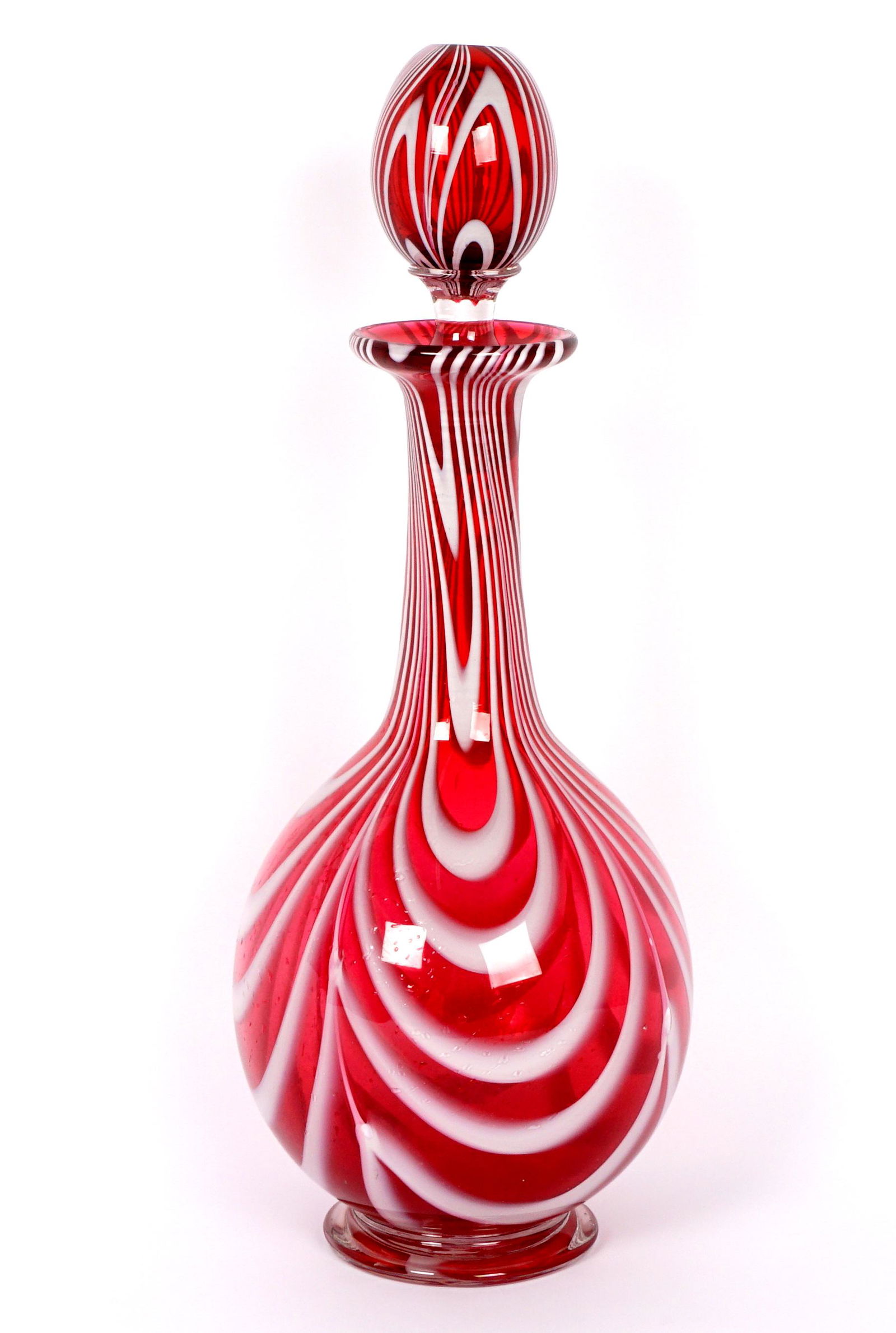 Nailsea Cranberry Art Glass Decanter: Long neck bulbous decanter, pulled cranberry and white glass, complete with stopper, unmarked. Overall 13.5" h. x 5.25".