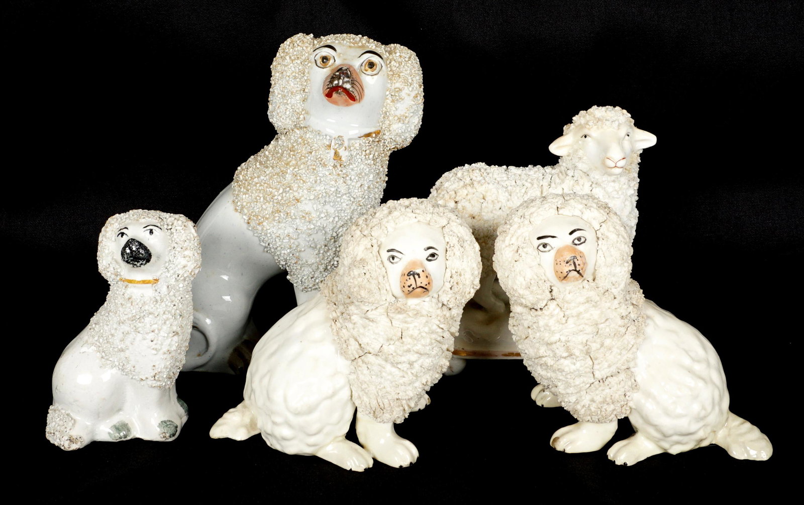 Five Pieces Staffordshire Poodles and Sheep: An assembled collection of five pieces total to include four poodles and one sheep. Tallest poodle measures 6" h. x 4.75" x 2.25".