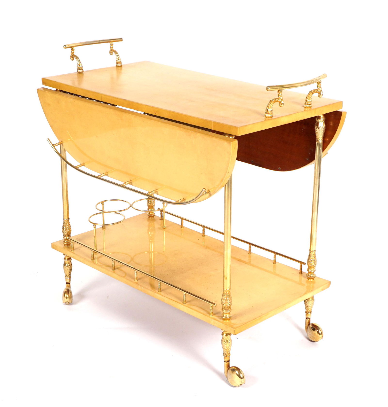 Aldo Tura Lacquered Goat Skin Drop Leaf Bar Cart: Tan lacquered goat skin with brass handles, galleries, and three bottle rings, all on castors. Overall measures 29.5" h. x 31.5" x 16.5". Each drop leaf 8". Condition: Minor wear.