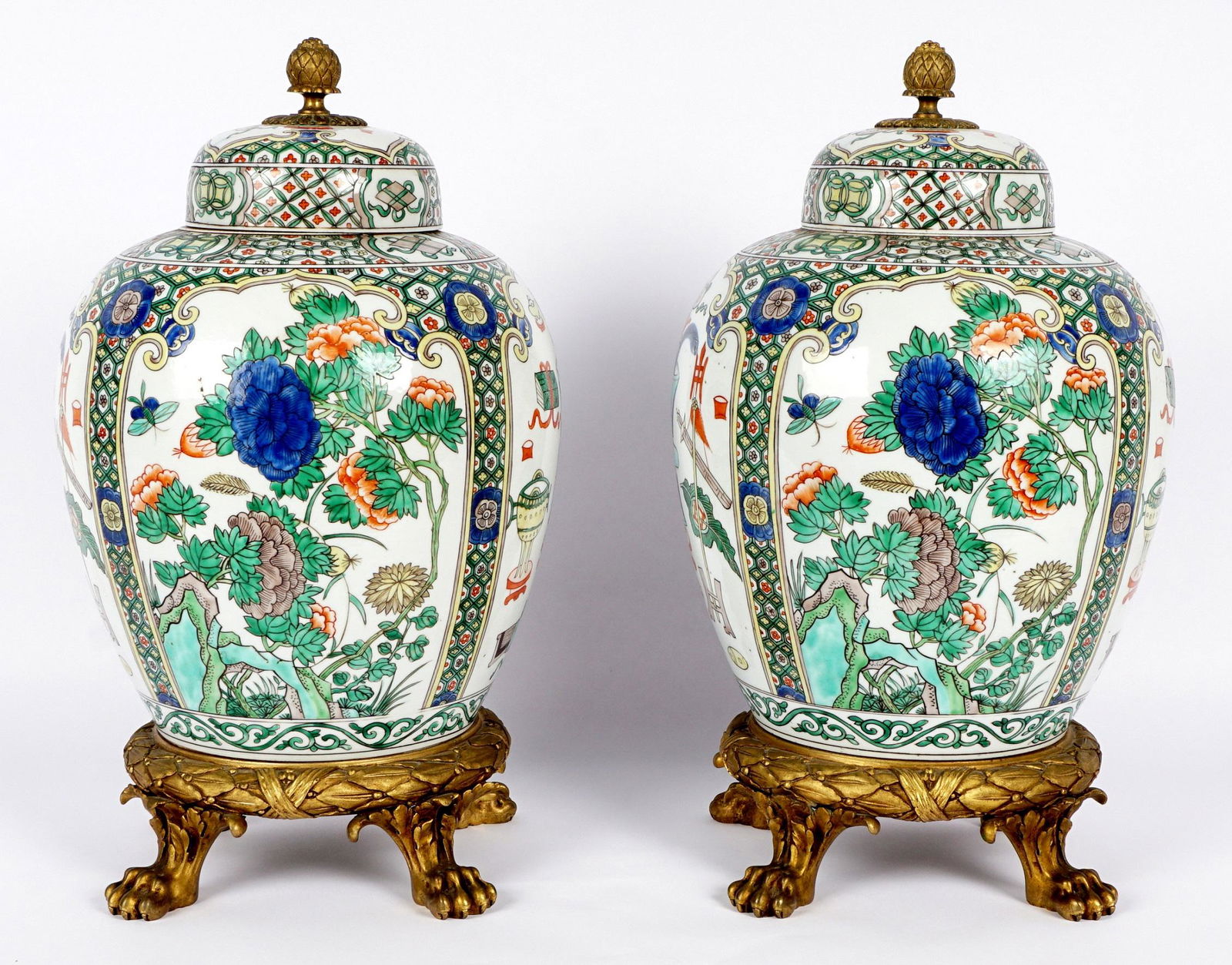 Pair Famille Rose Bronze Mounted Jars: Pair of Chinese Famille Rose decorated ginger jars, lid with gilt bronze pineapple finial, body decorated with alternating panels of floral and precious objects in reserves. French gilt bronze mounted