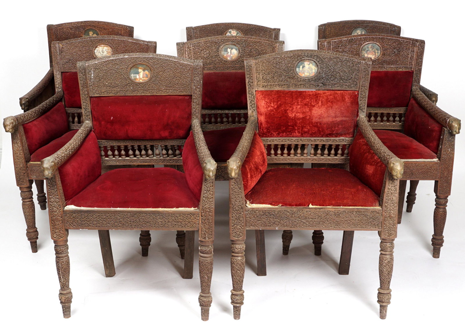Set of Eight Anglo-Indian Carved Arm Chairs: Each with profusely carved frames, carved figural cat head hand holds, six with baluster lower rails, two without. Each chair has hand painted medallions on the front of top rails and on each side, th