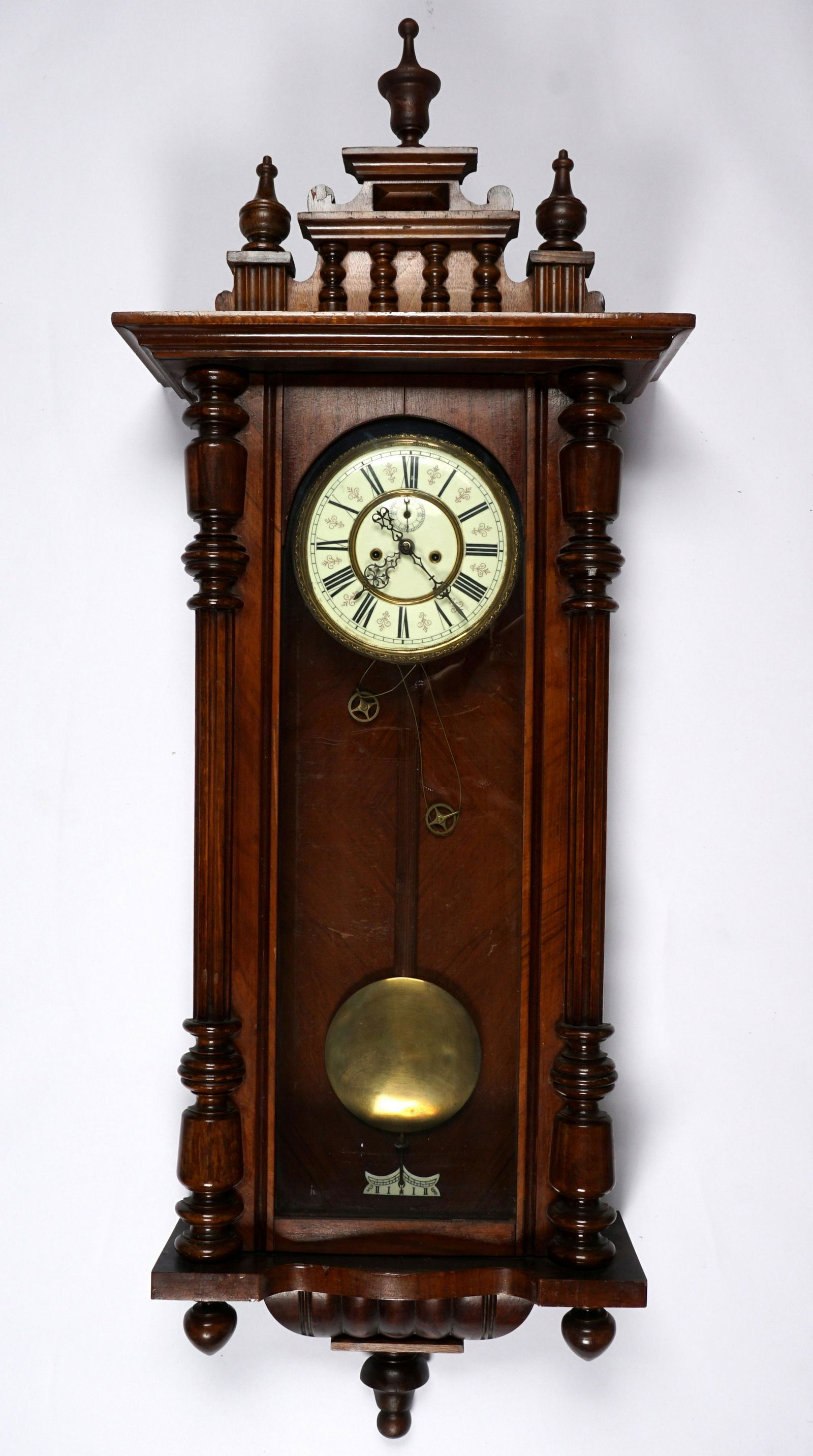 Germania Dual Weight Vienna Regulator Clock: Walnut case with removable architectural pediment, hand painted porcelain dial, Roman numerals, dual weight driven time and gong strike movement with Germania RG crown and anchor mark. Overall measure