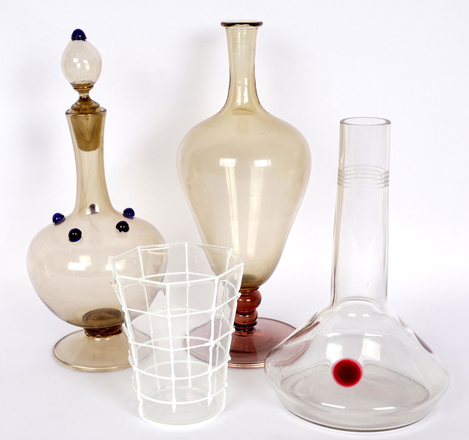 Collection of Four Continental Art Glass Vases: An assembled collection of four pieces total to include 1) Octagonal tapering to round glass vase with applied white threading, 5.25" h. x 4". Loss of threading. 2) Attributed Josef Hoffmann long neck