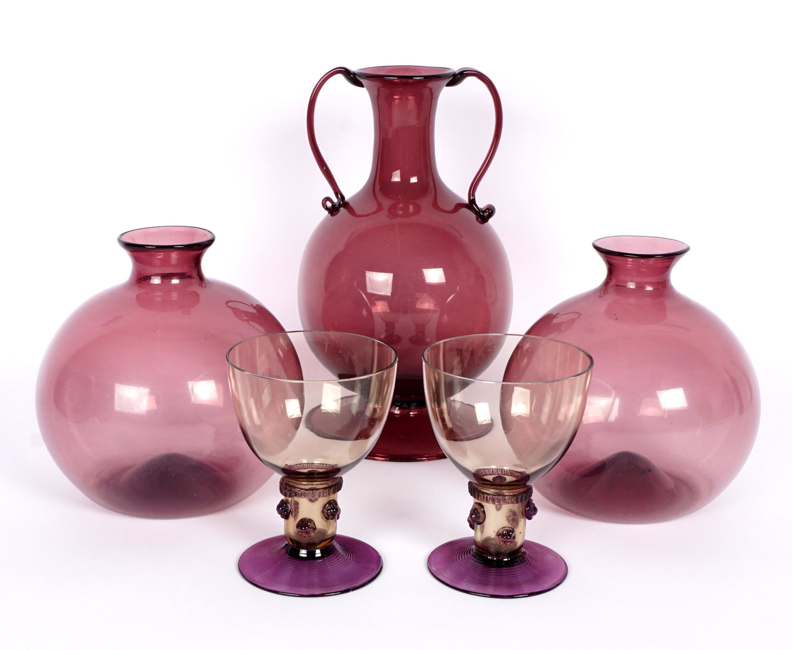Collection of Five Continental Amethyst Glass: An assembled collection of five pieces total to include 1) Double handled vase, 8" h. x 4.75". 2-3) Pair bulbous vases / jars, 5.25" h. x 5.25". 4-5) Pair of cordial glasses , amber glass bowl, applie