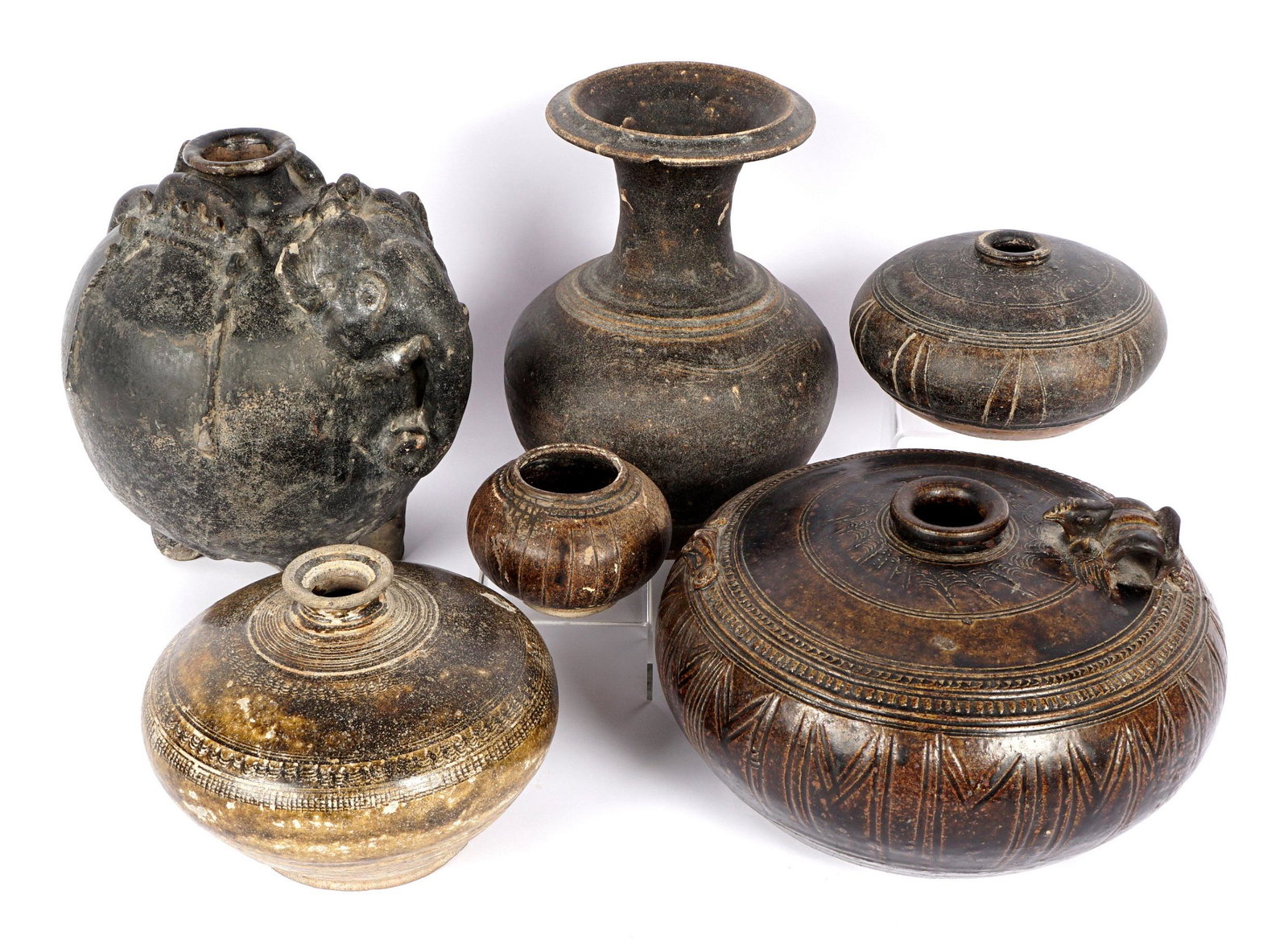 Six Piece Cambodian Khmer Pottery Vessels: Six pieces total, primarily 11th to 14th Century Cambodian Khmer ceramic pottery to include 1) Grey glaze elephant form jar / vessel, 9" h. x 9.25". 2) Brown glaze jar, figural bird handle, beak spout