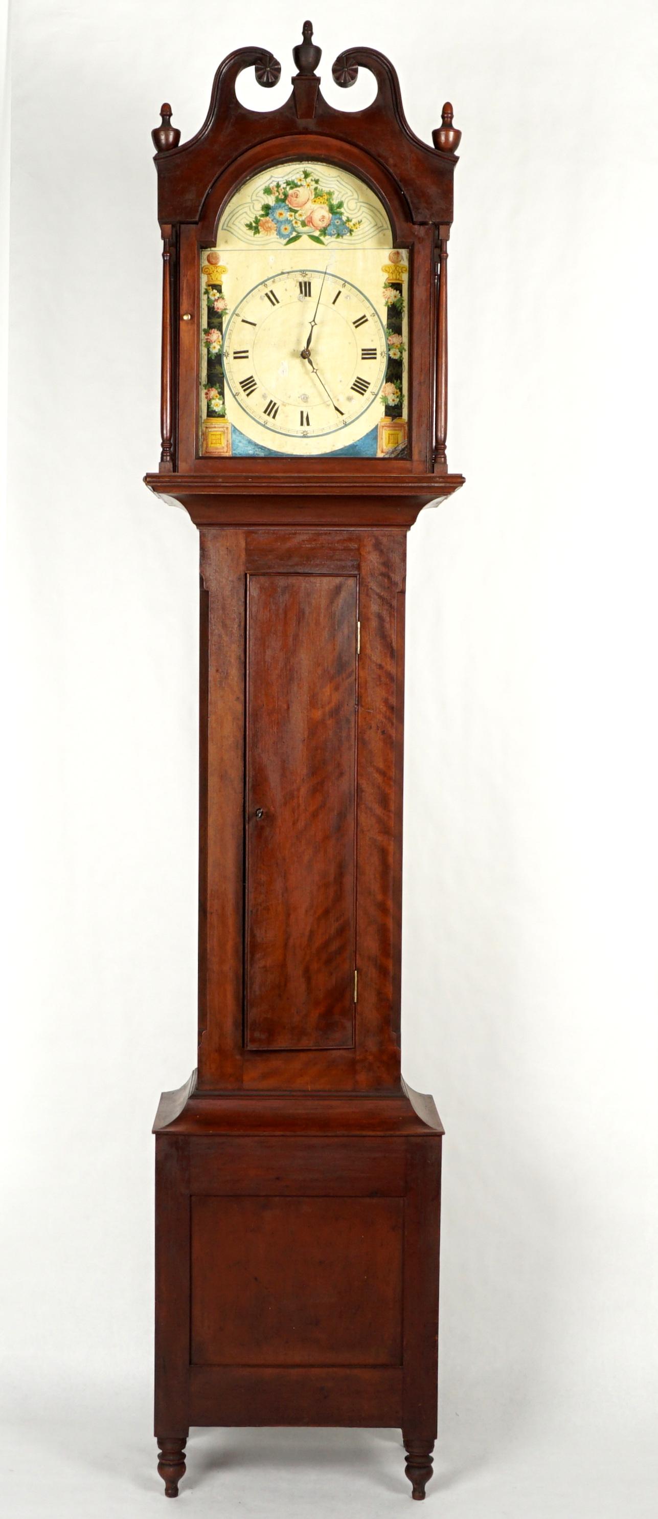 19th Century Pennsylvania Tall Case Clock: Early to mid 19th Century, bonnet with swan neck broken arch pediment, turned urn finials, blind door trunk, base on four turned legs. Hand painted tin dial, floral column decorated, wood gear time an