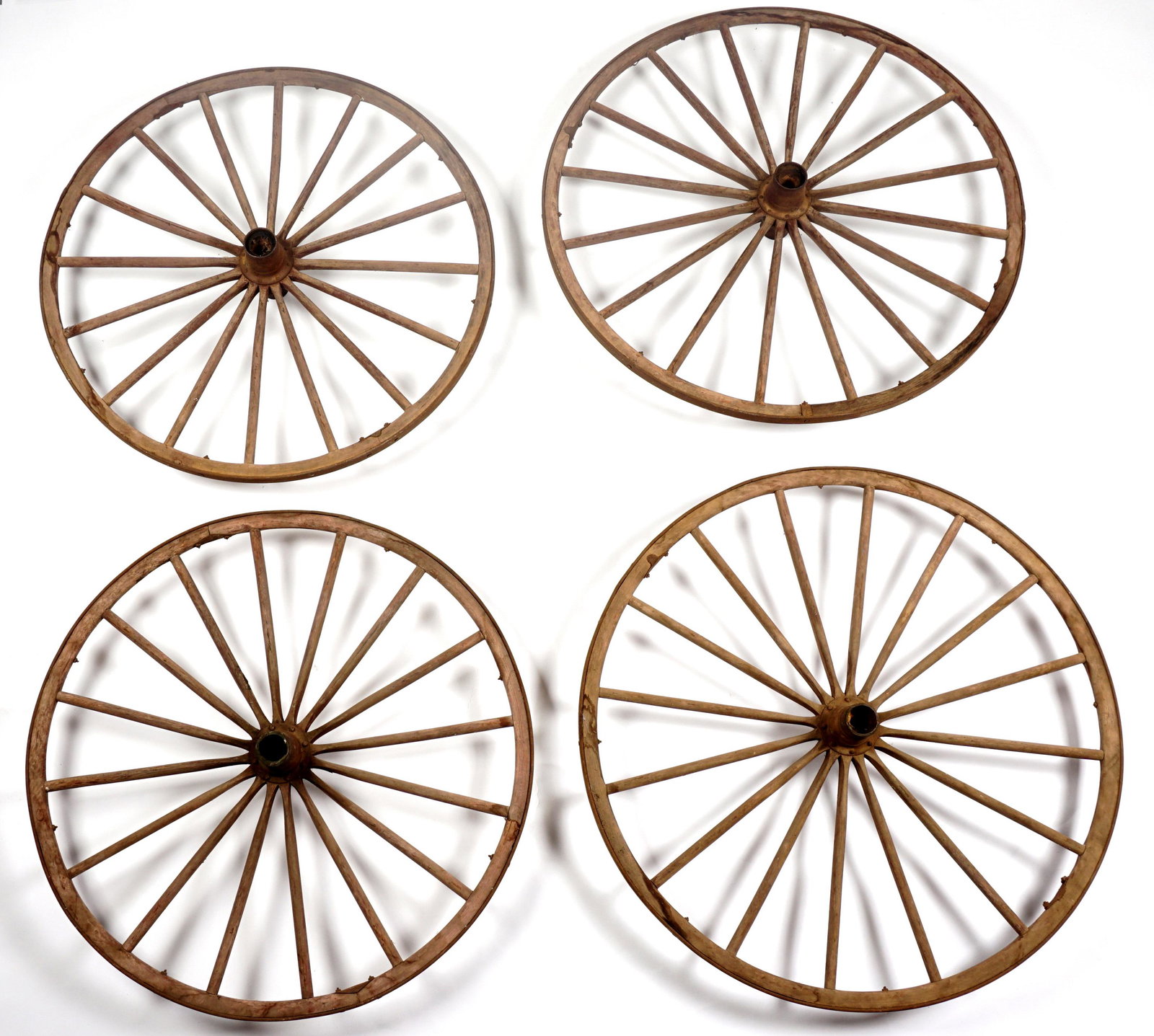 Four Large Vintage Stagecoach Wagon Wheels: Set of four, two larger back and smaller front pairs, wrought iron and wood construction, larger measures 415" h. x 8", Condition: Obvious wear.