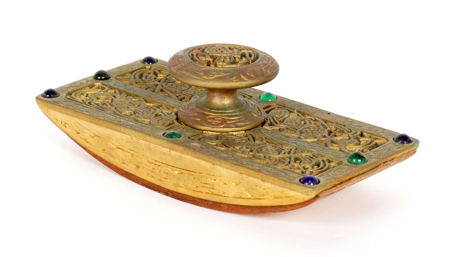 Tiffany Studios Gilt Bronze 9th Century Blotter: Gilt bronze rocker blotter in the Ninth Century pattern by Tiffany Studios, accented with glass jewels, well marked Tiffany Studios, 1628. 2" x 5.5 "x 2.5". Condition: Uneven finish, verdigris.