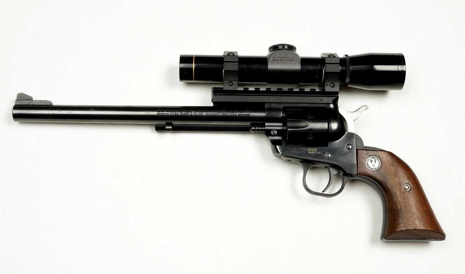 Ruger New Model Single Six .22 Revolver w/ Scope: Ruger New Model Single Six, .22 caliber, 9.5" blued round barrel, wood grips, Leupold M8 scope with 2x extender, serial number 69-65264 dates to 1982. Overall 15.25". Condition: Minor wear, clean and