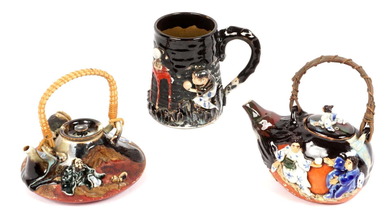 Three Piece Japanese Sumida Gawa Teapots & Mug: Three pieces total to include 7) Low teapot, seated figure and vase, wicker handle, signed on plaque, 5.5" h. x 6". 2) Teapot with 3 figures, wicker handle, signed on plaque, 6.5" h. x 7". 3) Mug with