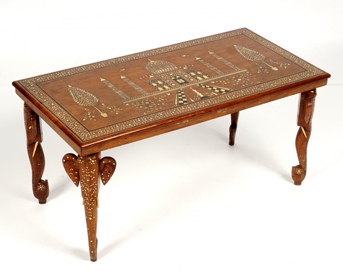 Indian Inlaid Taj Mahal Coffee Table: Rectangular coffee table, bone and ebony inlaid top with Taj Mahal and foliate scene, carved figural elephant legs with foliate bone inlay, overall 17.5" x 36" x 18". Condition: Missing tusks, wear co