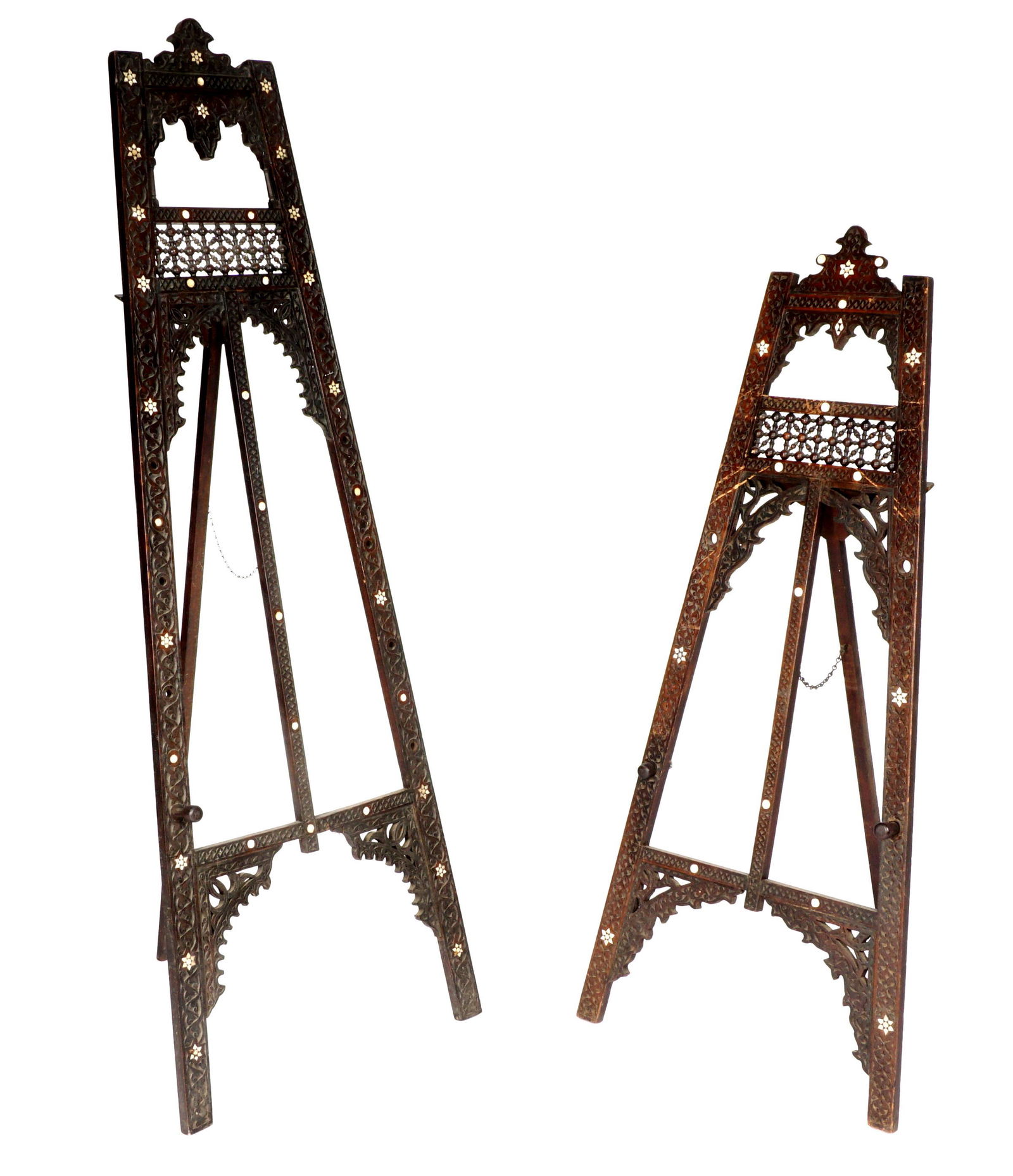 Pair Antique Syrian / Moorish Inlaid Floor Easels: Matched pair, one larger than the other, profusely carved all over with inlaid bone stars and dots, adjustable pegs, larger measures 67" h .x 24.25" x 1.75", smaller 54.5" x 23.5" x 1.75". Condition: