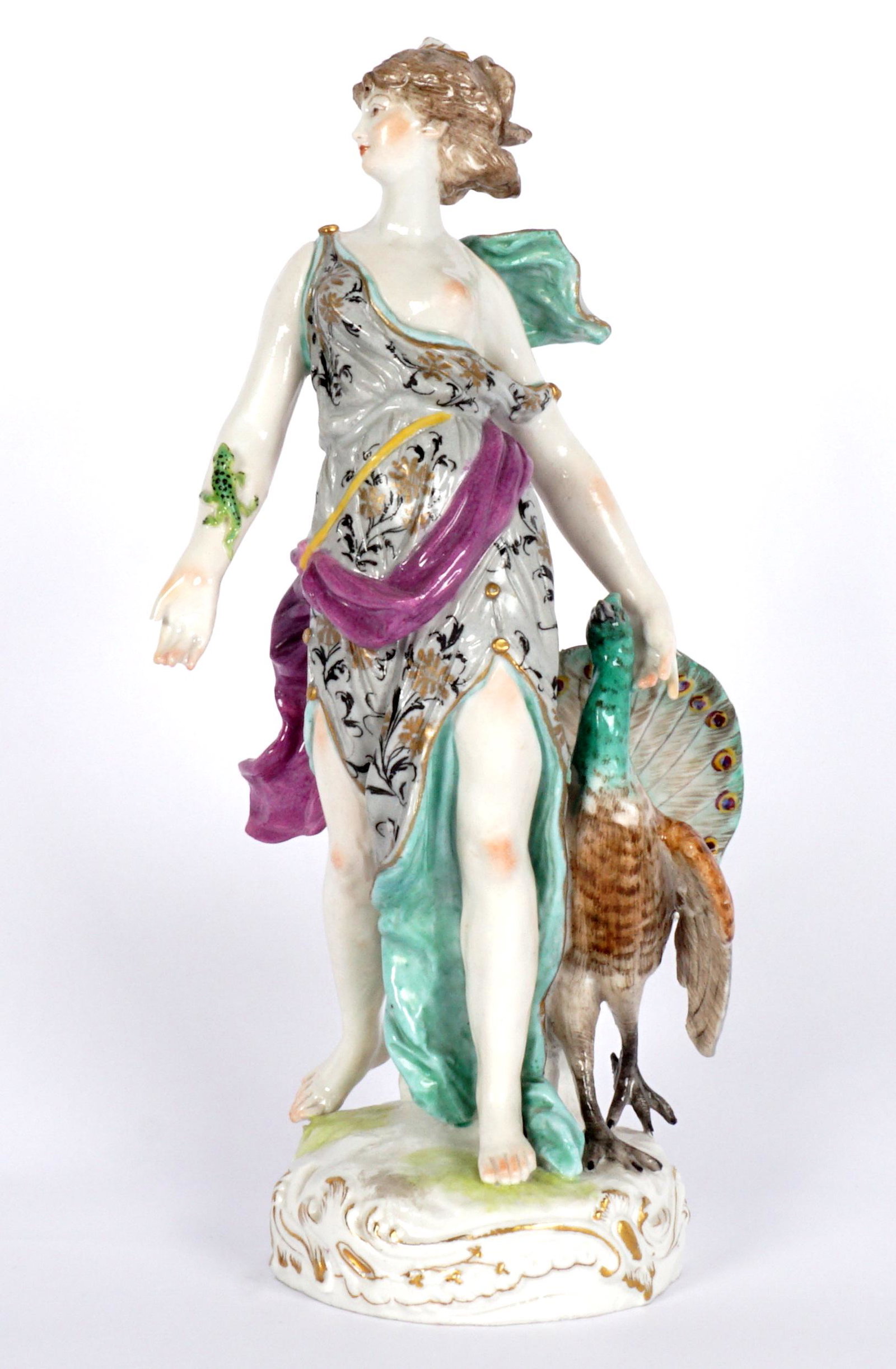 Meissen Porcelain Figure of Hera with Swan: Figure of Hera with lizard on her arm, standing with peacock, blue crossed swords mark on base, overall 11.25" x 5.75. Condition: Missing part of thumb.