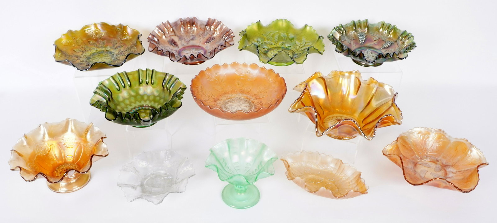 12 Assorted Carnival Glass Bowls: 12 pieces total to include 1-2) Fenton Holly, 8.25" dia, and 9" dia. 3) Unknown ruffled bowl, 4" h. x 10.5". 4) Dugan Ice Green Coin Spot compote, 4.5" x 6". 5) Northwood strawberry basket weave, 9".