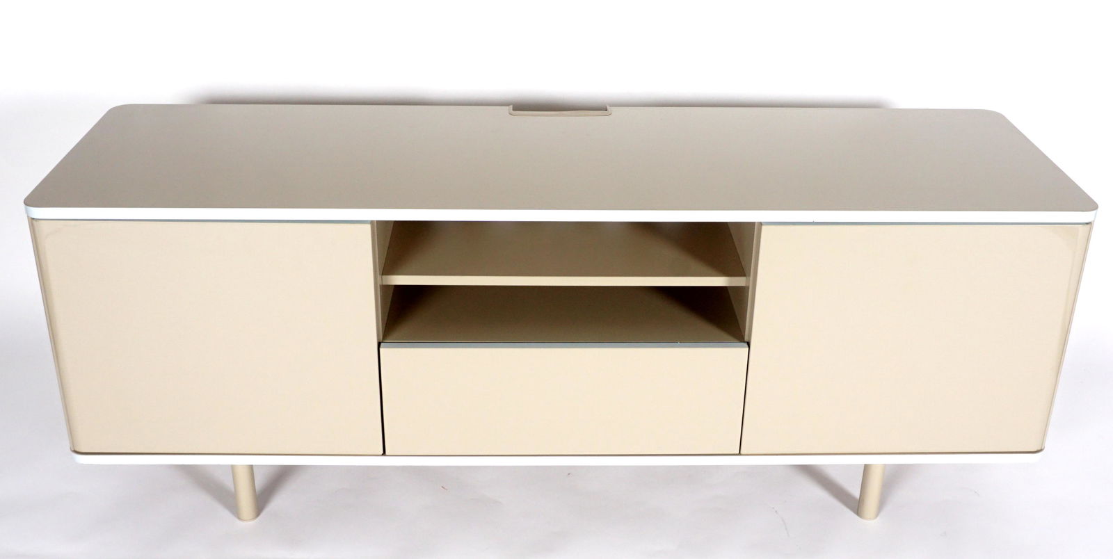 Contemporary Low Television Credenza: Beige finish, two doors, center open storage over drawer, on four legs, overall 23.75" h. x 63" x 18.5". Condition: Minor signs of use.