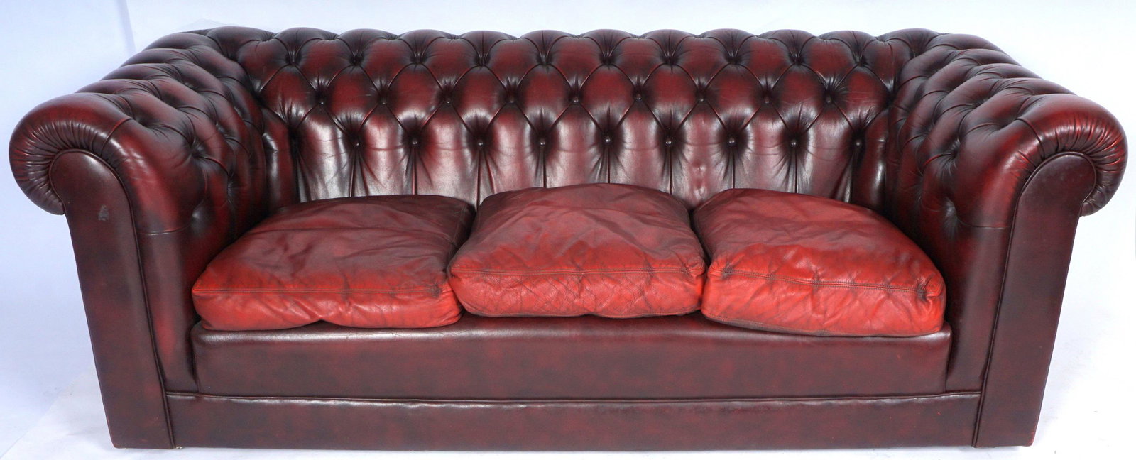 Red Leather Chesterfield Sofa & Club Chair: Ox blood red leather with tufted buttons, sofa measures 28" h. x 82" x 38". Matching chair measures 28" x 43" x 37". Condition: Used, some scratches and abrasions.