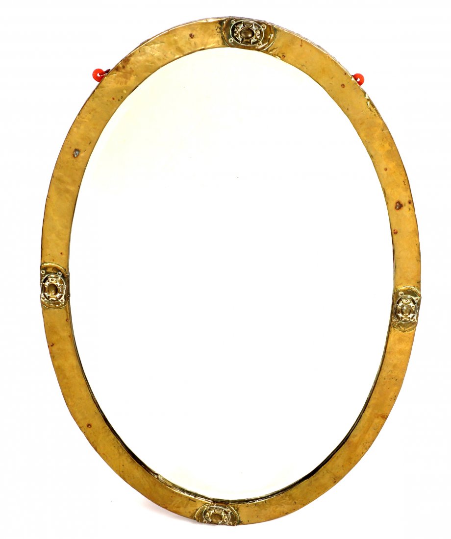 Attrib. Liberty & Co. Hammered Copper Wall Mirror: Hammered copper frame with applied embossed decoration, beveled oval mirror, overall 23.75" x 22.75" x 1.5". Condition: Spots of verdigris.