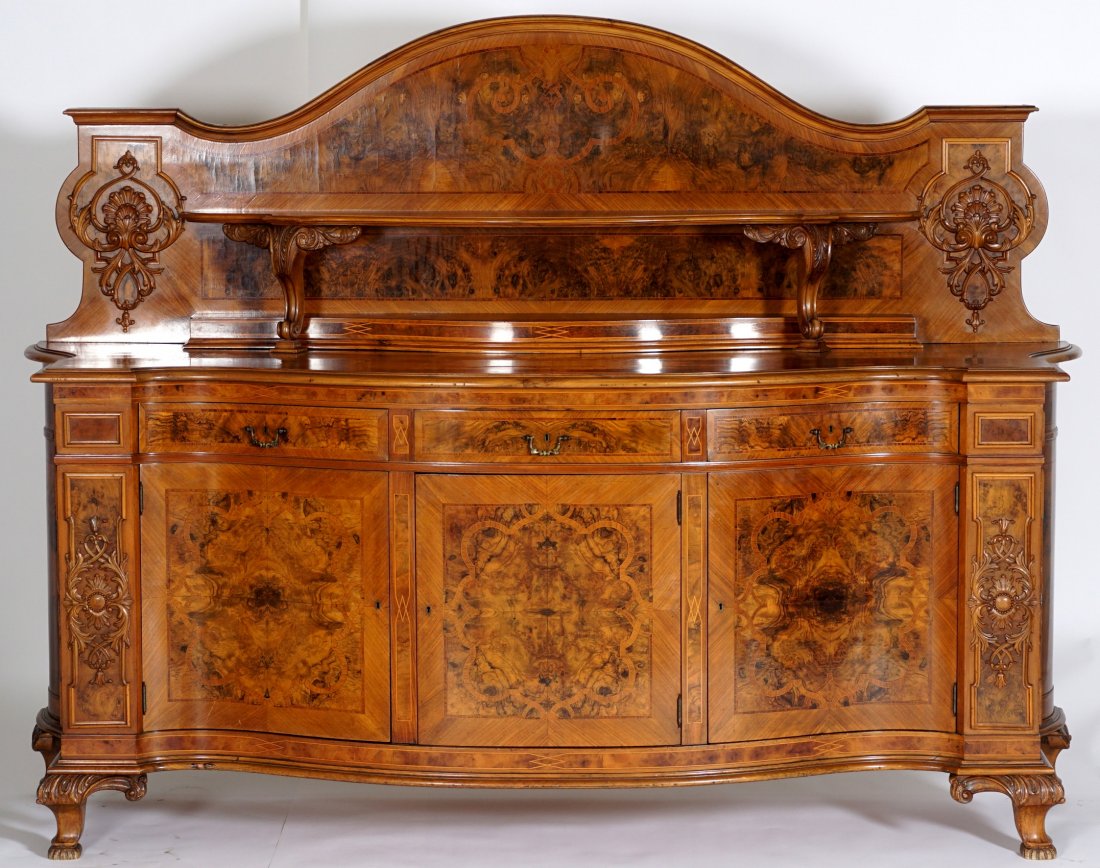 Carved Italian Walnut Sideboard: Arched crest with parquetry inlay and carved decoration, serpentine upper shelf, carved acanthus leaf and scroll supports. Parquetry inlaid serpentine top over 3 drawers over 3 doors, matching inlay.