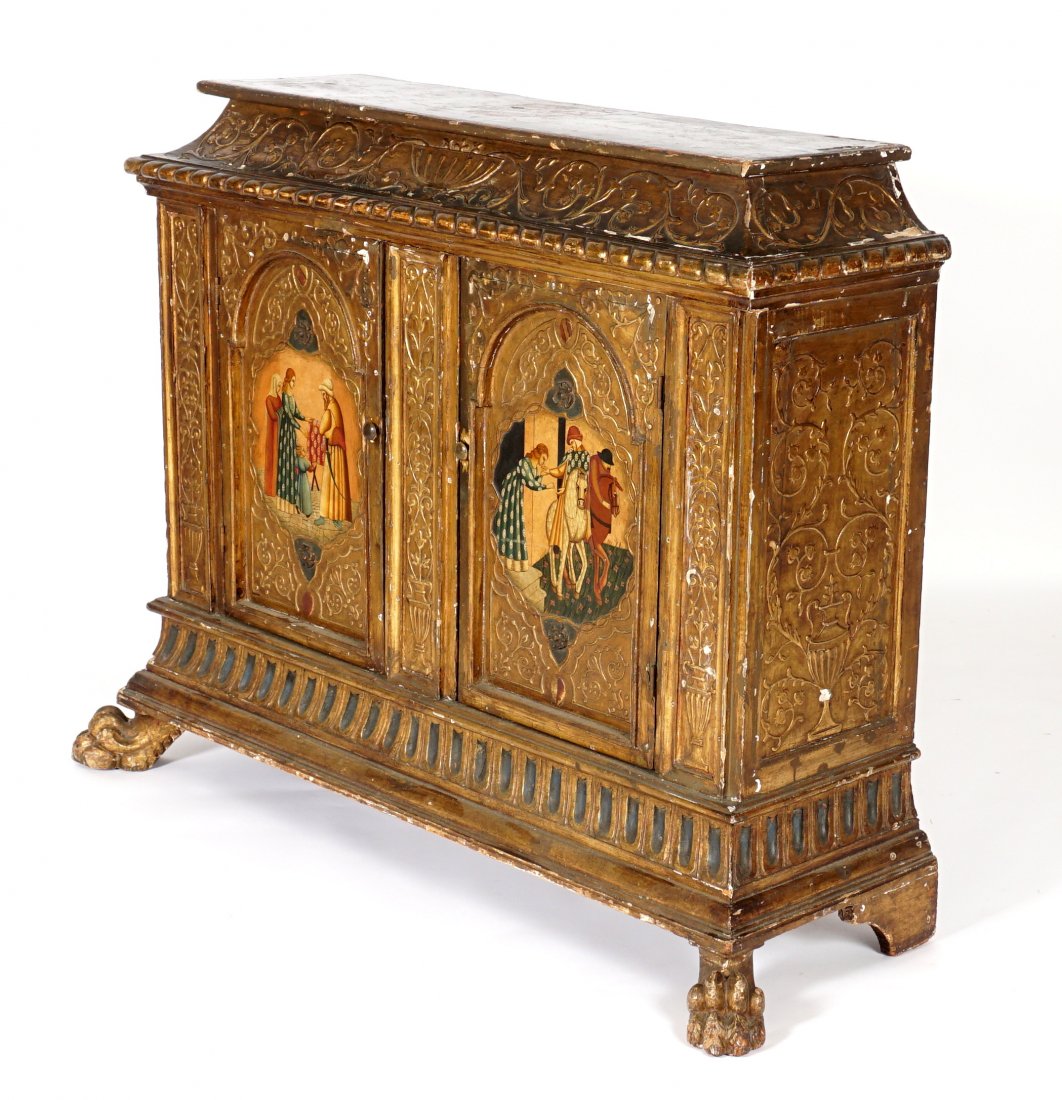 18th/19th C. Italian Paint Decorated Credenza: Carved and painted sarcophagus form top, foliate and shield decoration over two carved doors, center medieval genre scenes, carved foliate stiles, front paw feet. Overall 41" h. x 57" x 19". Condition
