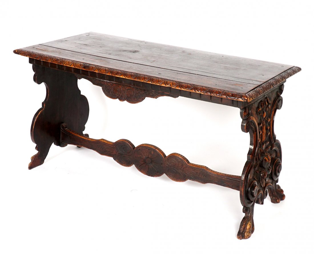 Pine and Walnut Italian Trestle Table: Four board top, carved border, carved and shaped supports with bow, flower, fruit, and pinecone decoration, carved support. Overall 31" h. x 59" x 29". Condition: Edge chips, scratches, other wear con