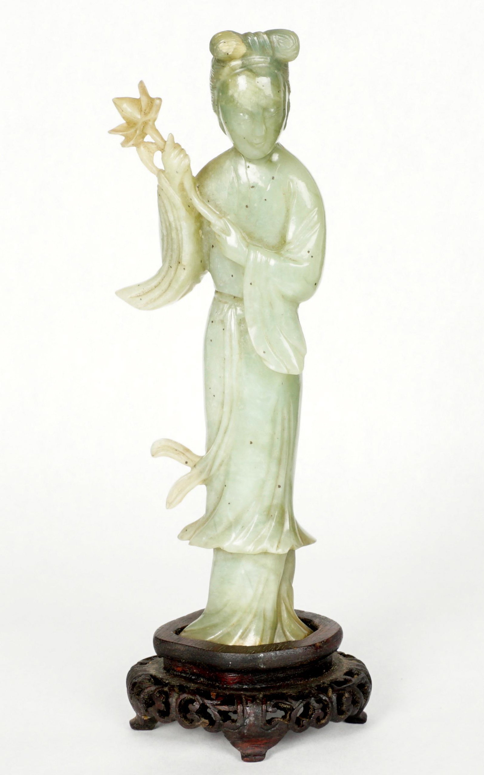 Chinese Carved Jade Figure of Guanyin: Carved standing figure of Guanyin holding lotus flower, affixed to carved wood stand, 8.25" h.
