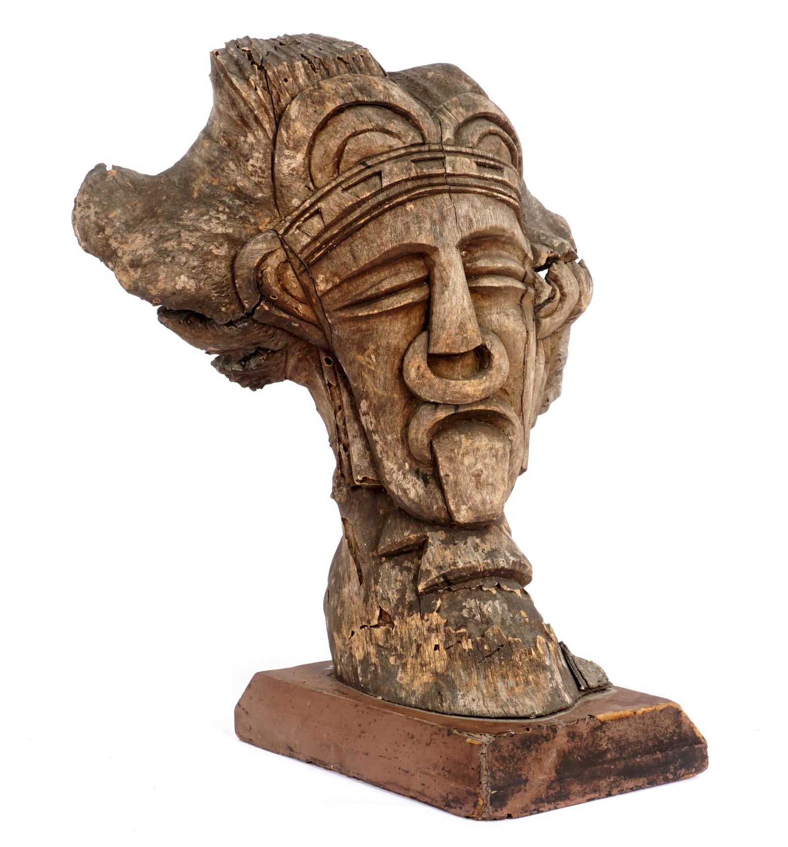 Ethnographic Carved Wood Bust of Pierced Nose Man: Most likely New guinea, older carved wood bust of a crowned man with pierced septum ring, open mouth with tongue sticking out. Affixed to wood plinth, overall 17" h. x 13.5" x 12.5". Condition: Age sp
