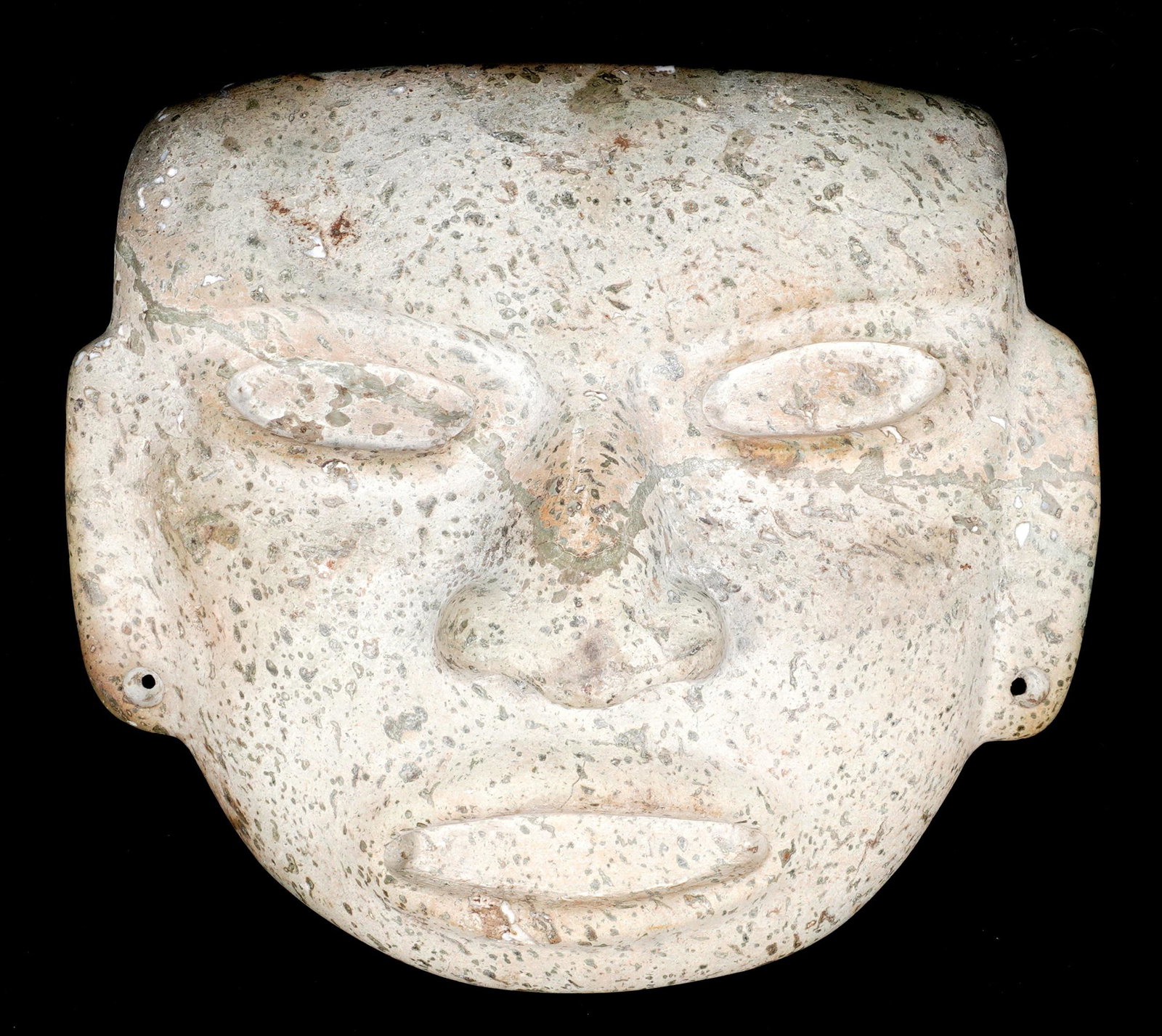 Classic Period Teotihuacan Stone Mask: Circa 450 A.D. - 650 A.D., Classic period grey-green mottled hardstone. Low brow over shallow sunken eyes and mouth drilled at corner for inlays, rectangular pierced ears, flared nose, pierced along u