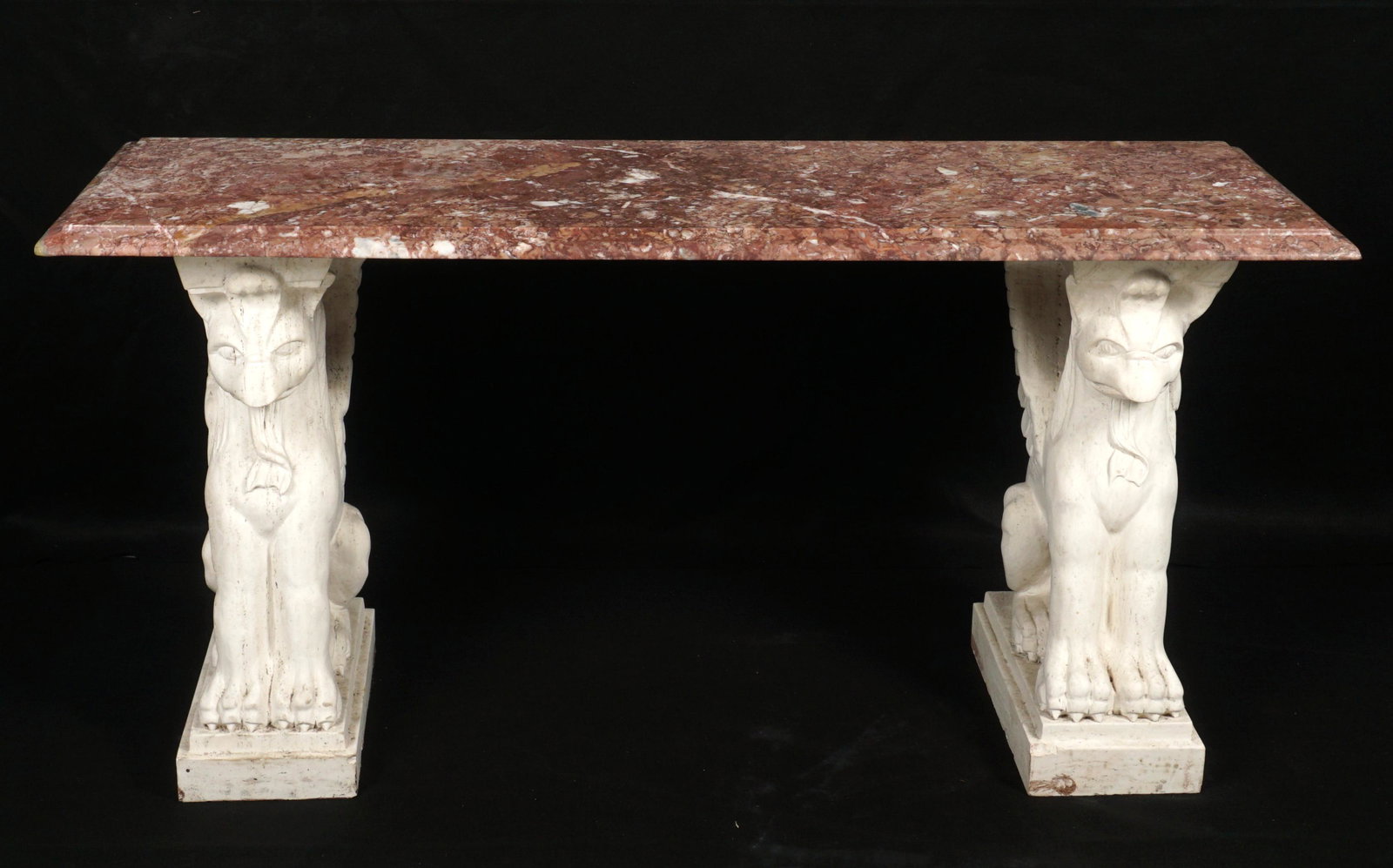 Carved Griffin Marble Top Console Table: Rectangular variegated rouge marble top supported by two figural marble griffins. Overall 30.75" x 63.5" x 21.75". Condition: Top with repair to one corner, scratches.